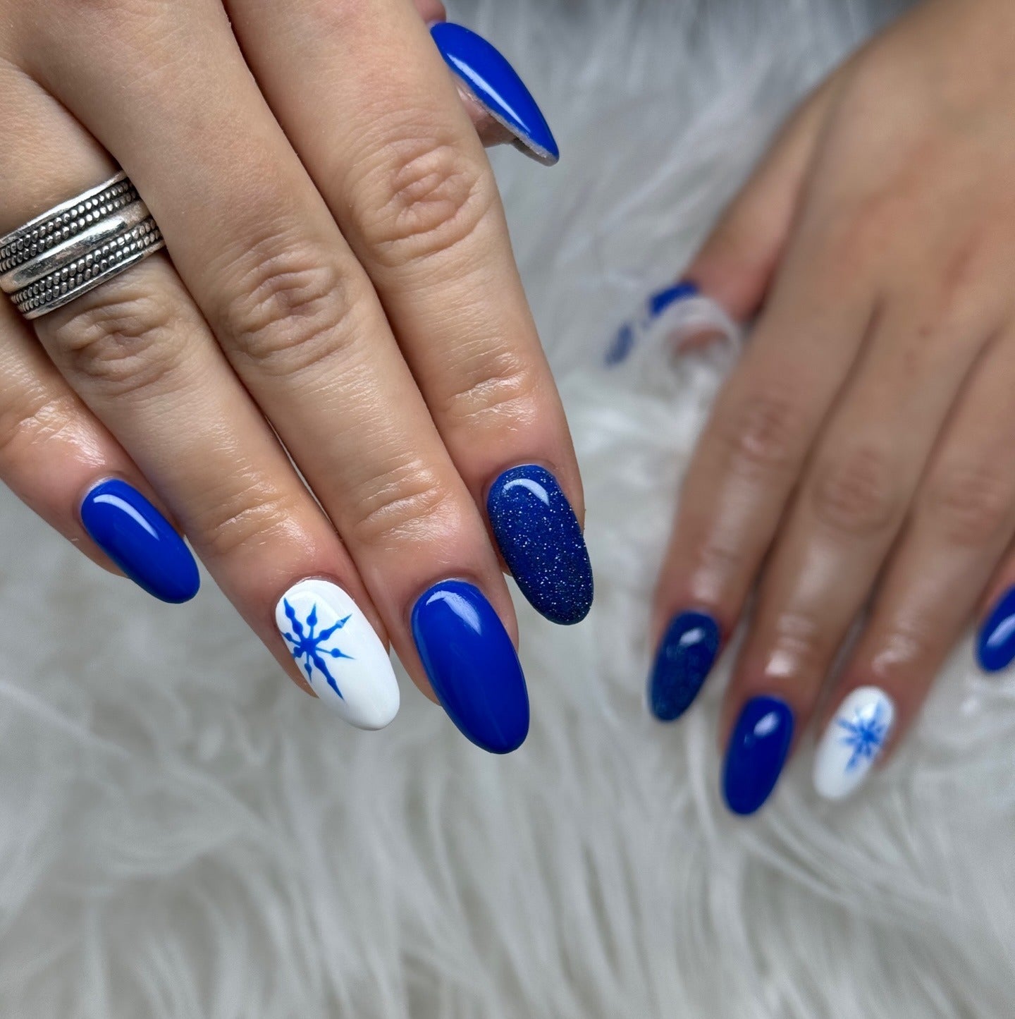 1. Royal Blue Sparkle with Snowflake Accents (Winter Almond Nail Ideas)