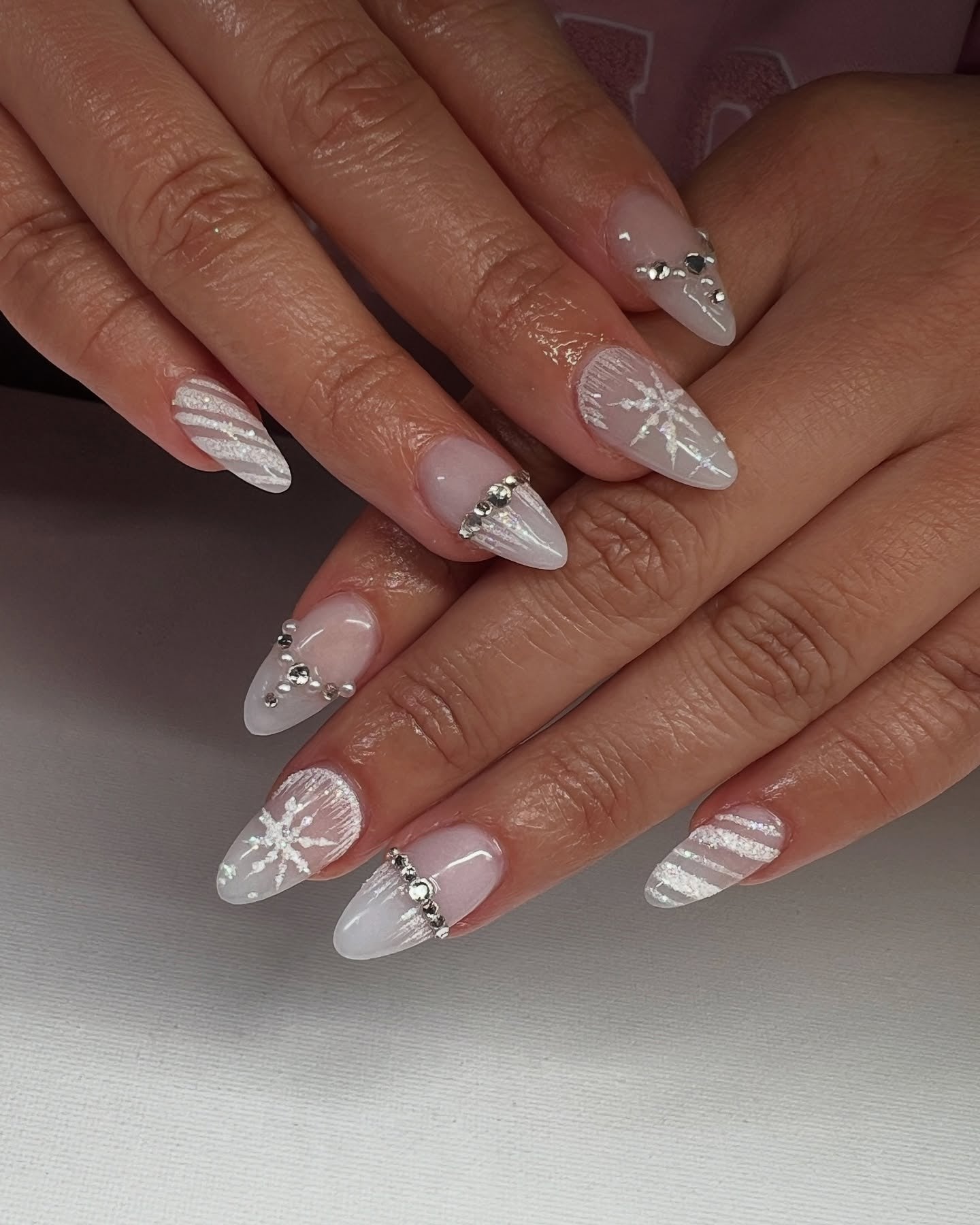 2. Crystal White Snowflakes with Metallic Accents (Winter Almond Nail Ideas)
