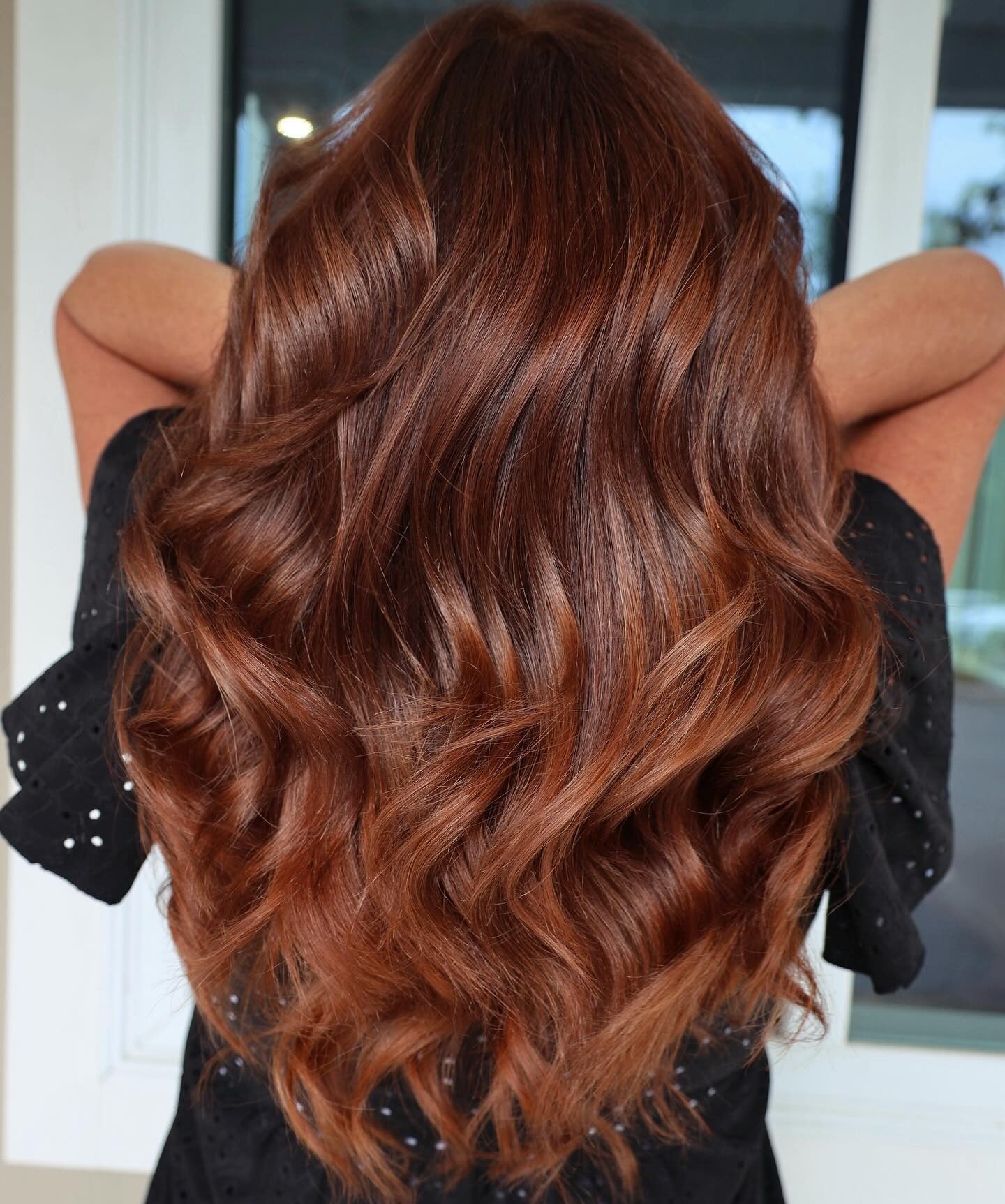 8. Voluminous Auburn Curls with Dimensional Shine (Dark Auburn Hair Color)