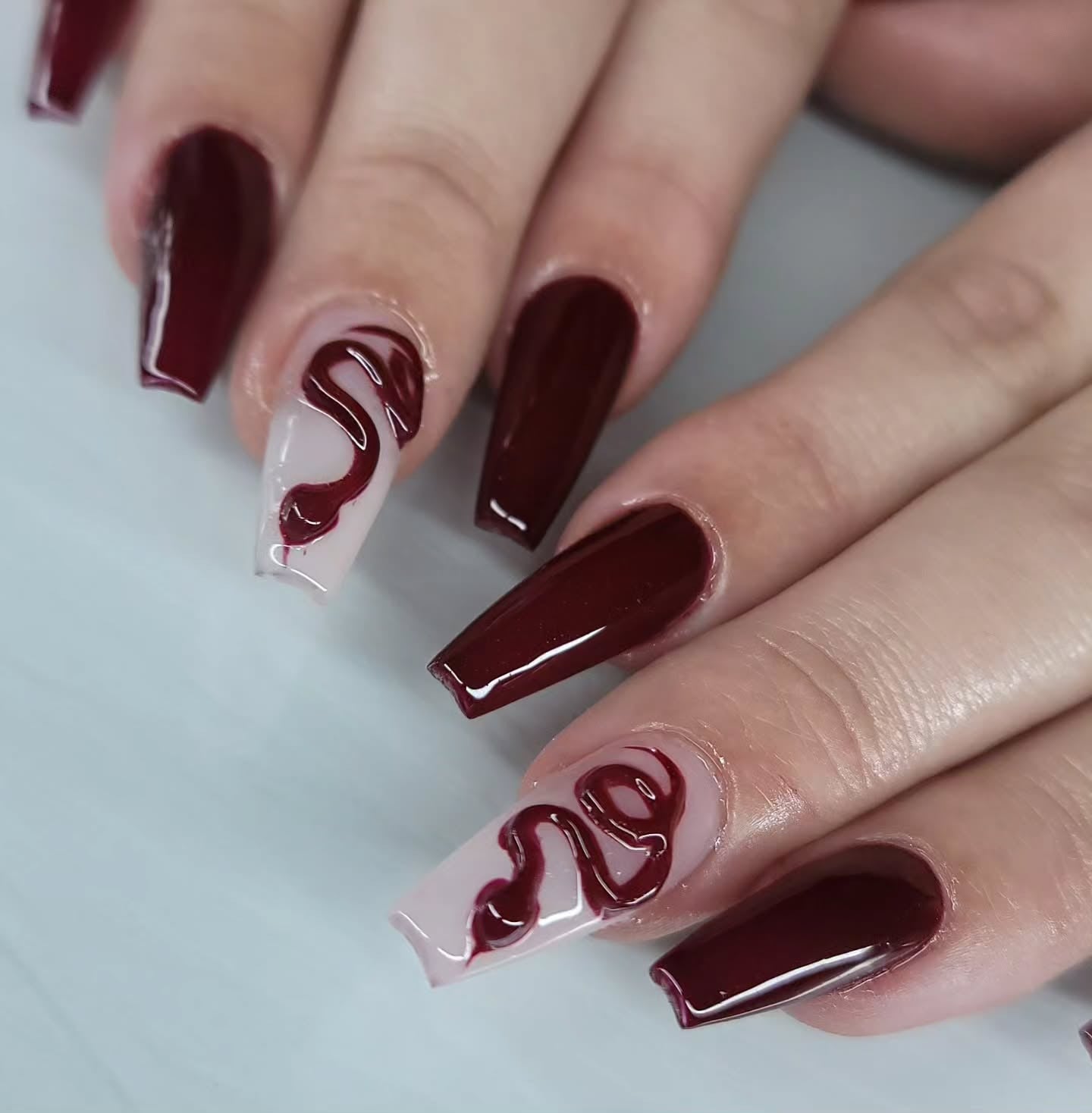 3. Dark Cherry Coffin Nails with Swirl Accent (Dark Red Coffin Nail Ideas)