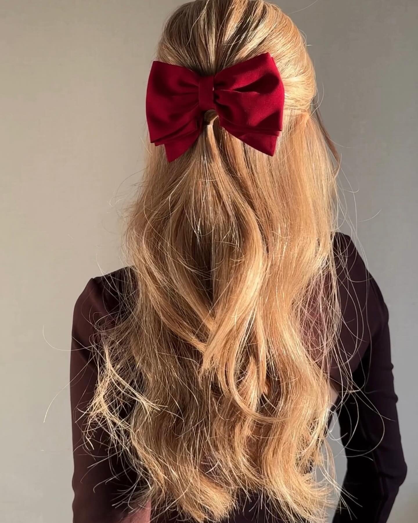 3. Loose Half-Up Waves with Crimson Bow in Warm Honey Blonde (Winter Hairstyles)