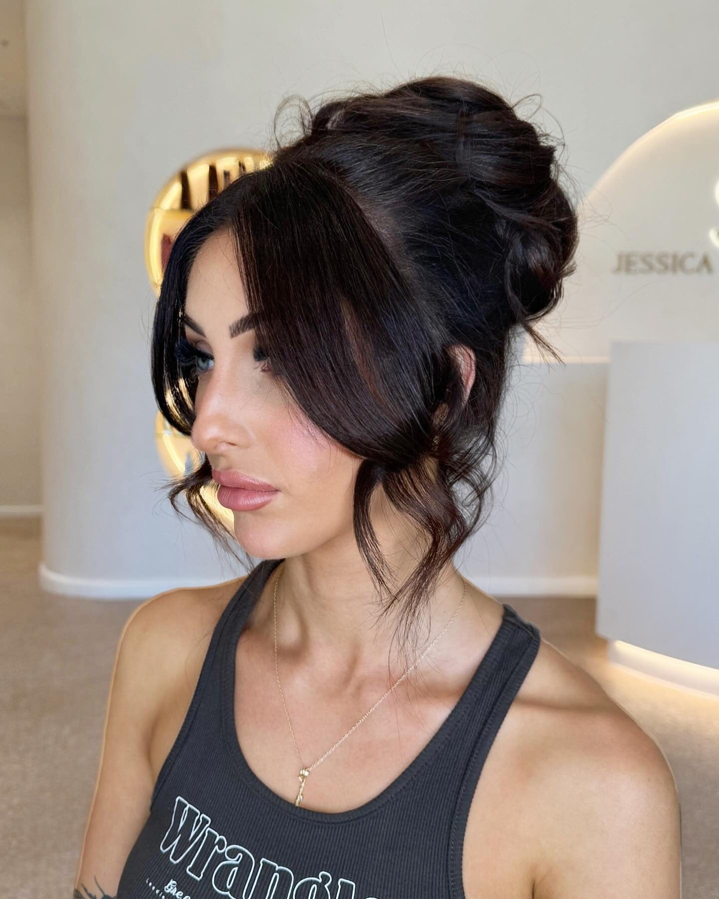 12. Tousled High Bun with Curtain Bangs in Espresso Brown (Winter Hairstyles)