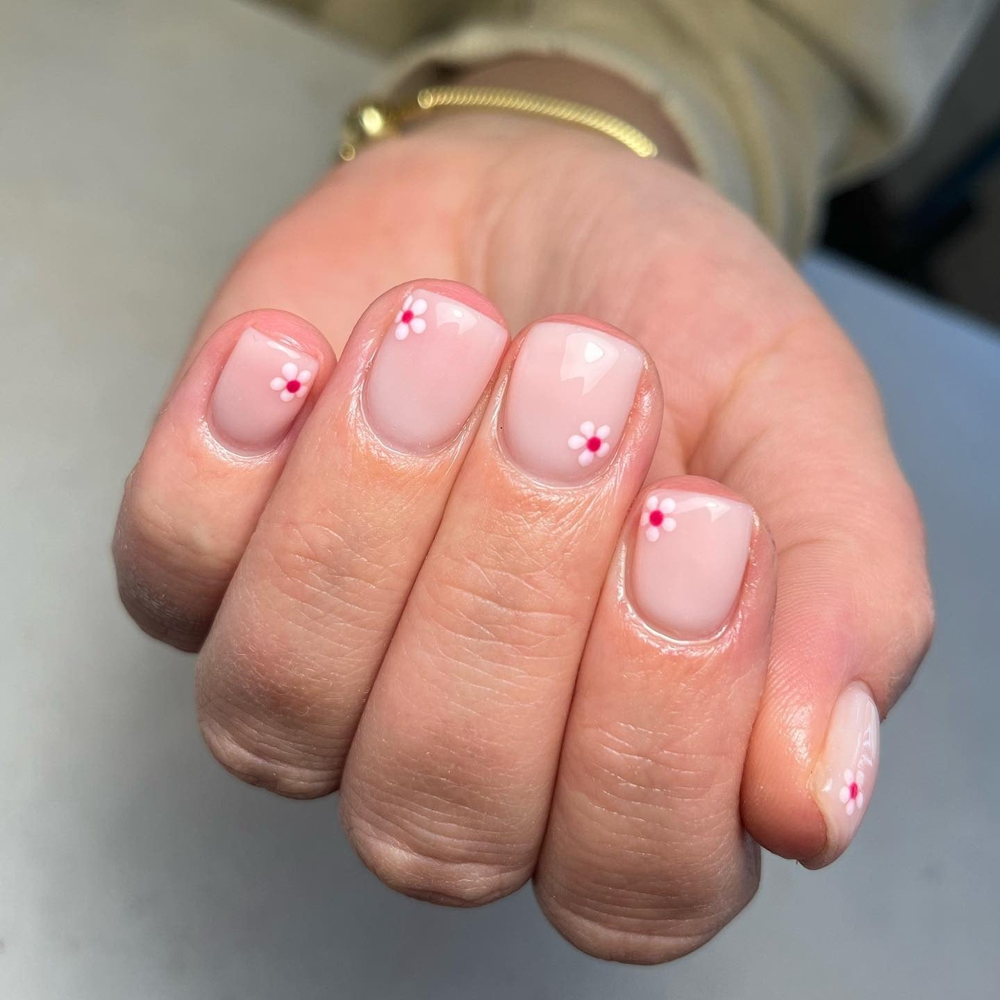11. Minimal Pink Daisies on Nude Base (Short Spring Break Nail Ideas)