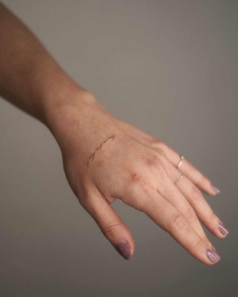 Small Script Hand Tattoo