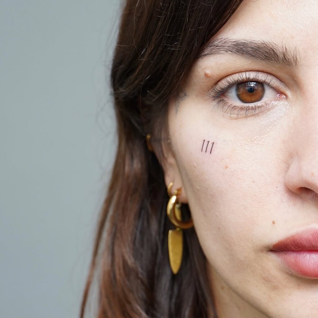Tiny Angel Number Face Tattoo 