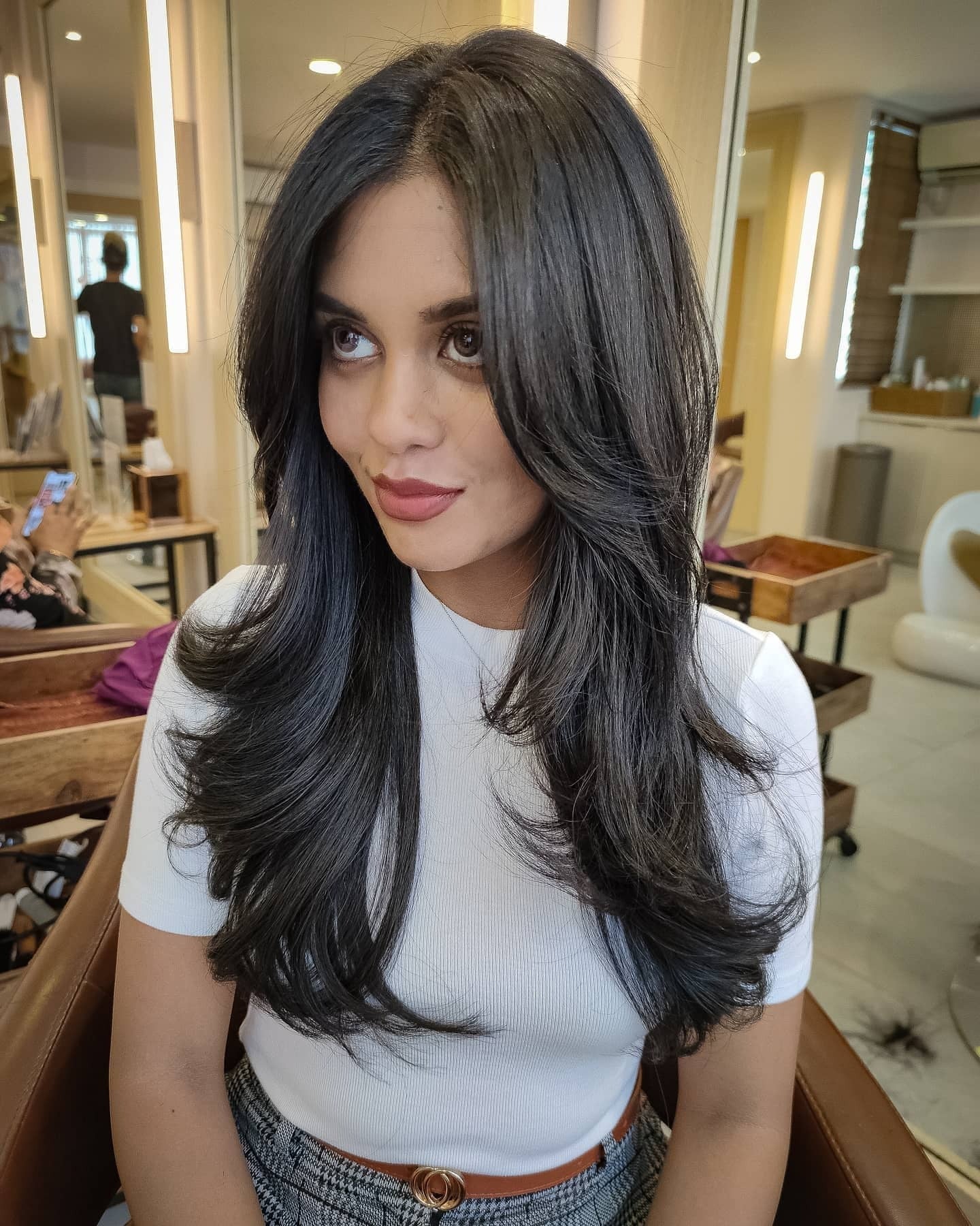 2. Glossy Black Layers with Soft Volume (Face-Framing Haircuts)