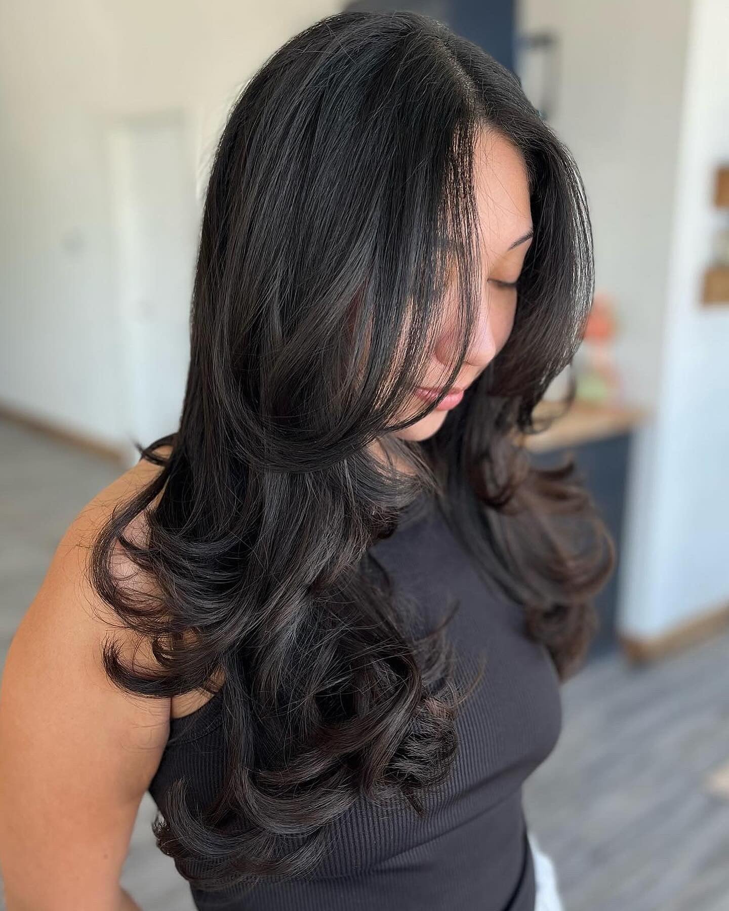 5. Deep Black with Softly Curved Layers (Face-Framing Haircuts)