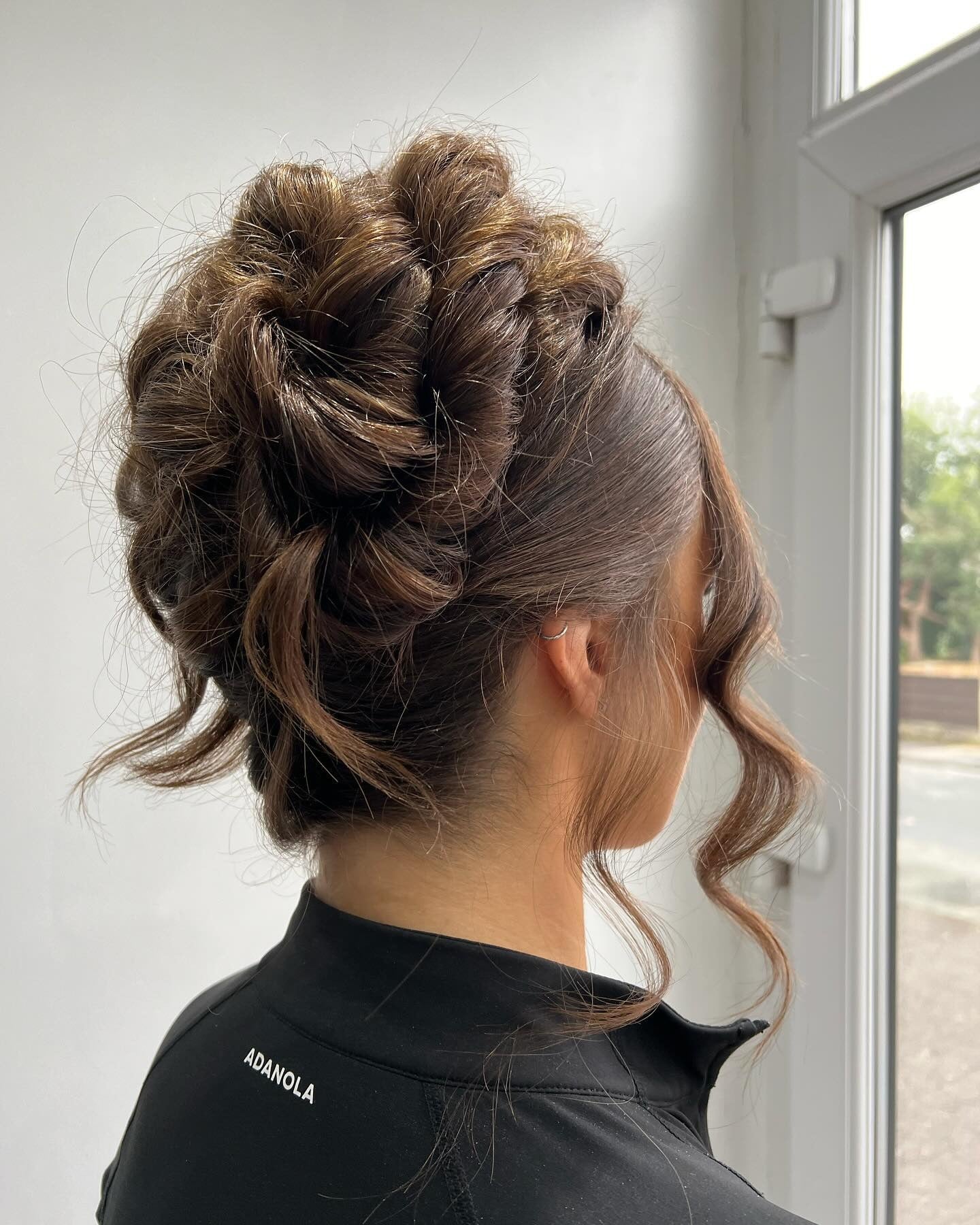 14. Braided Crown Bun with Loose Tendrils (Birthday Hairstyles)