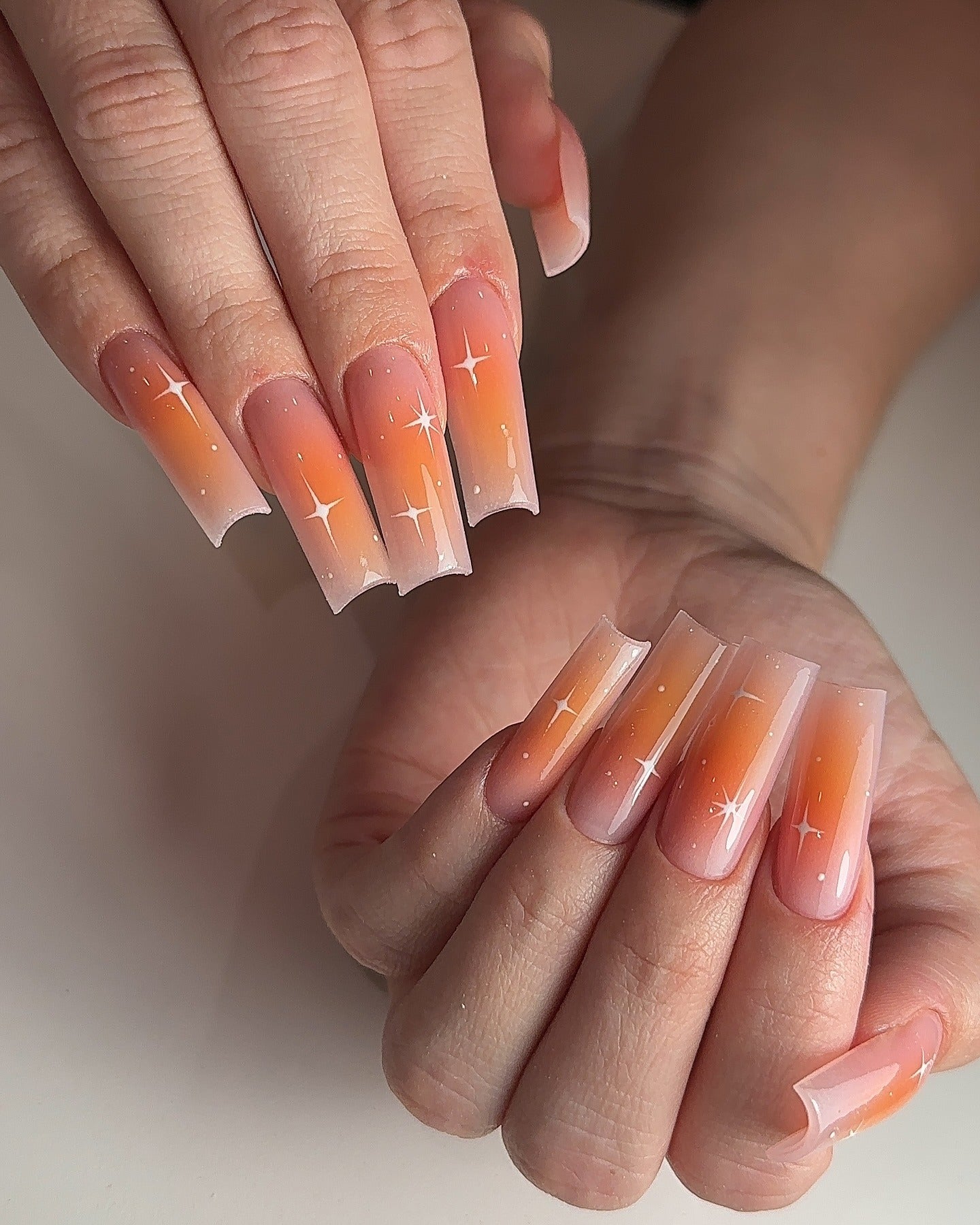3. Peach Glow Ombre with Star Accents (Orange Color Nail Ideas)