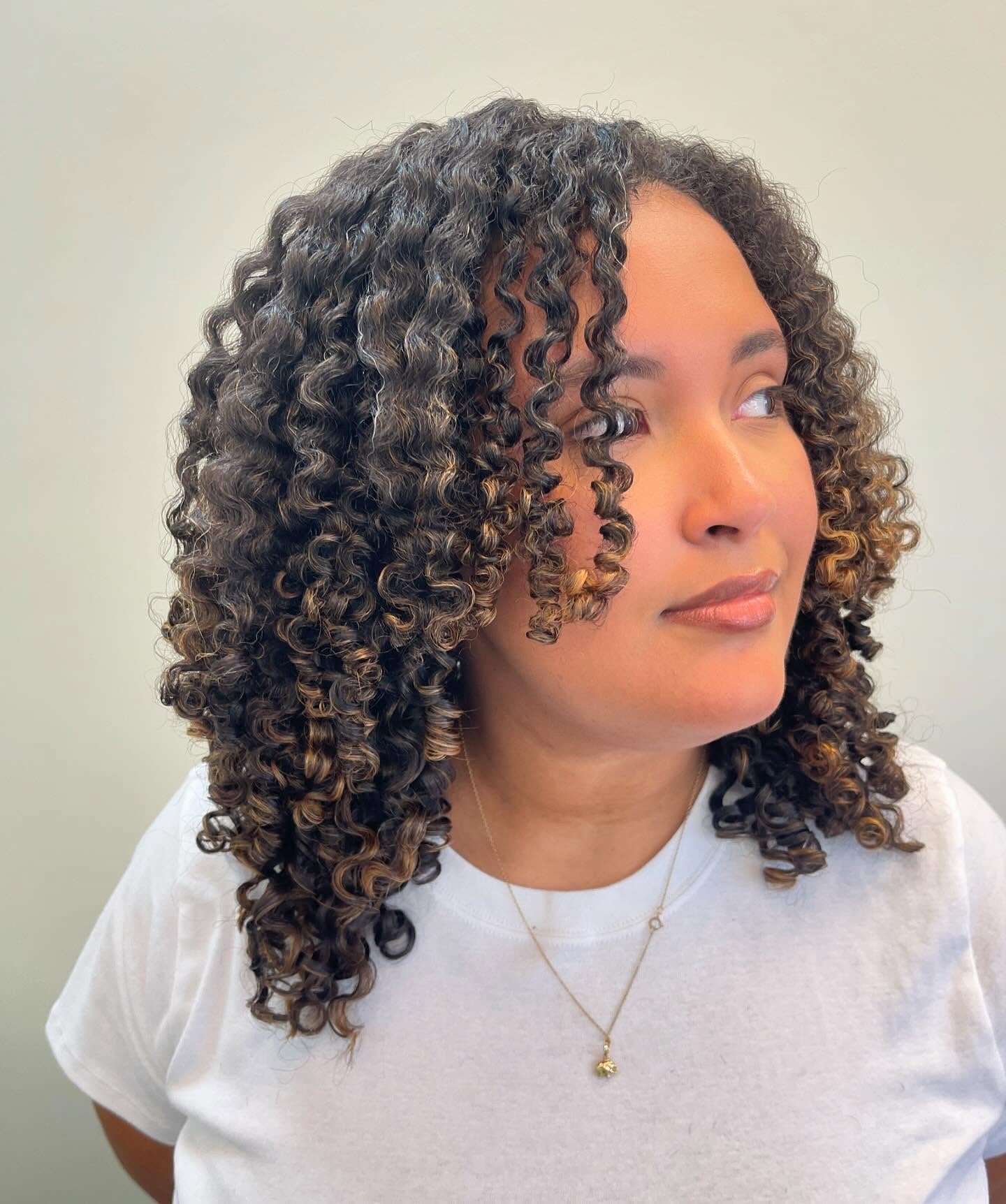 2. Caramel-Tipped Spiral Layers (Layered Curly Hairstyles)