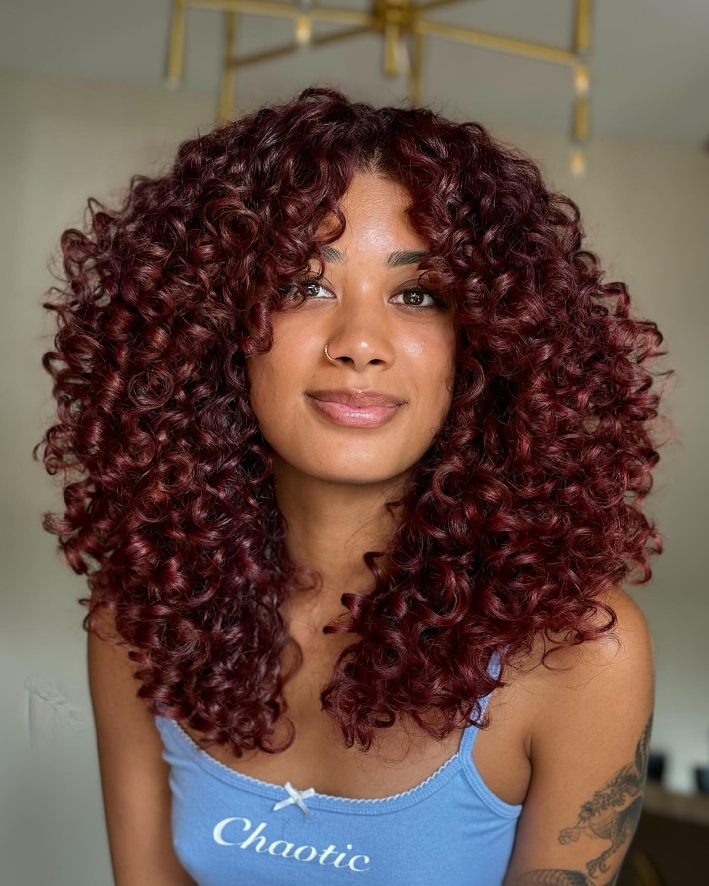 15. Burgundy Layered Curls with Soft Fringe (Layered Curly Hairstyles)