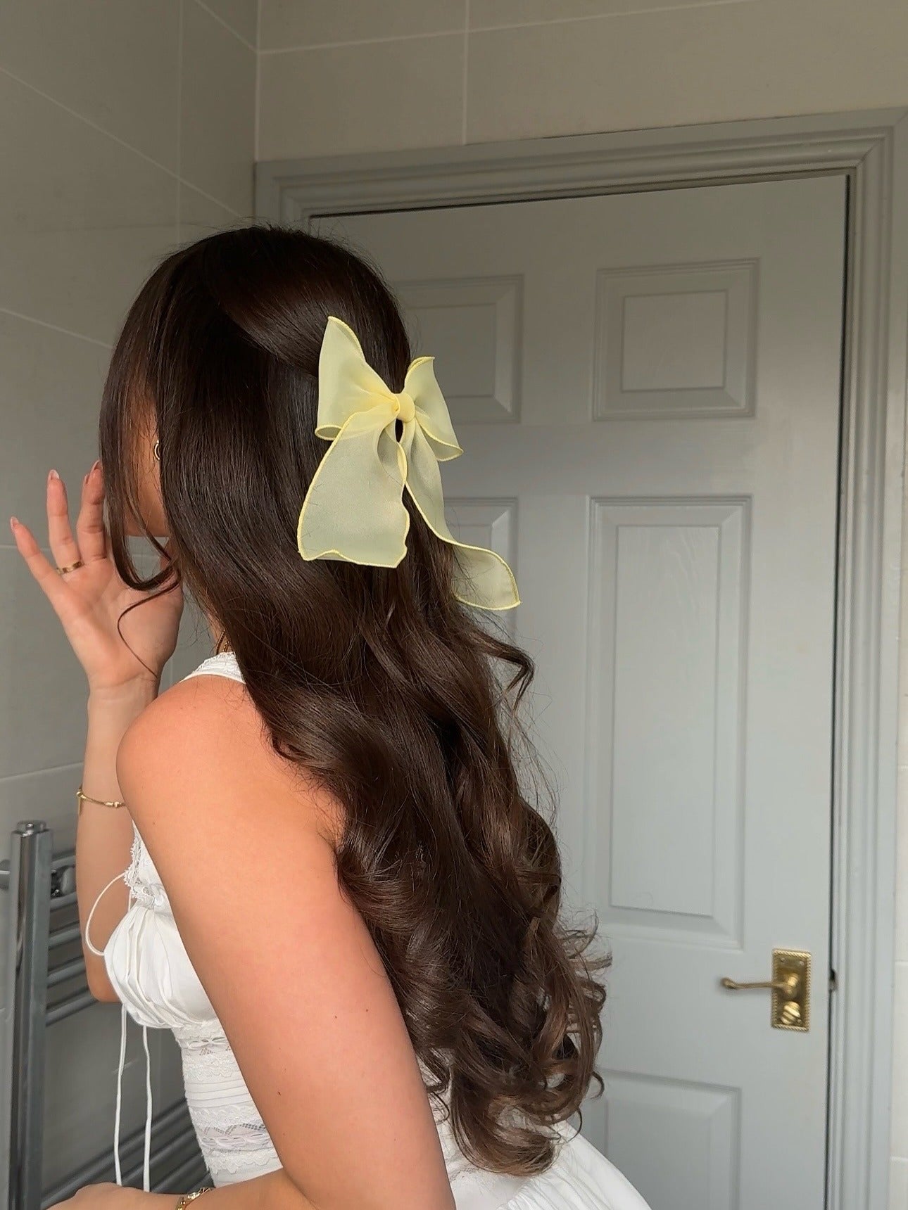 15. Curled Half-Up with Sheer Yellow Bow on Espresso Hair (Summer Hairstyles)