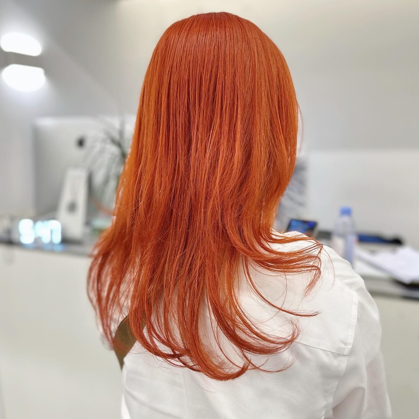 7. Feathered Orange Layers with Shine Finish (Orange Hair Color)