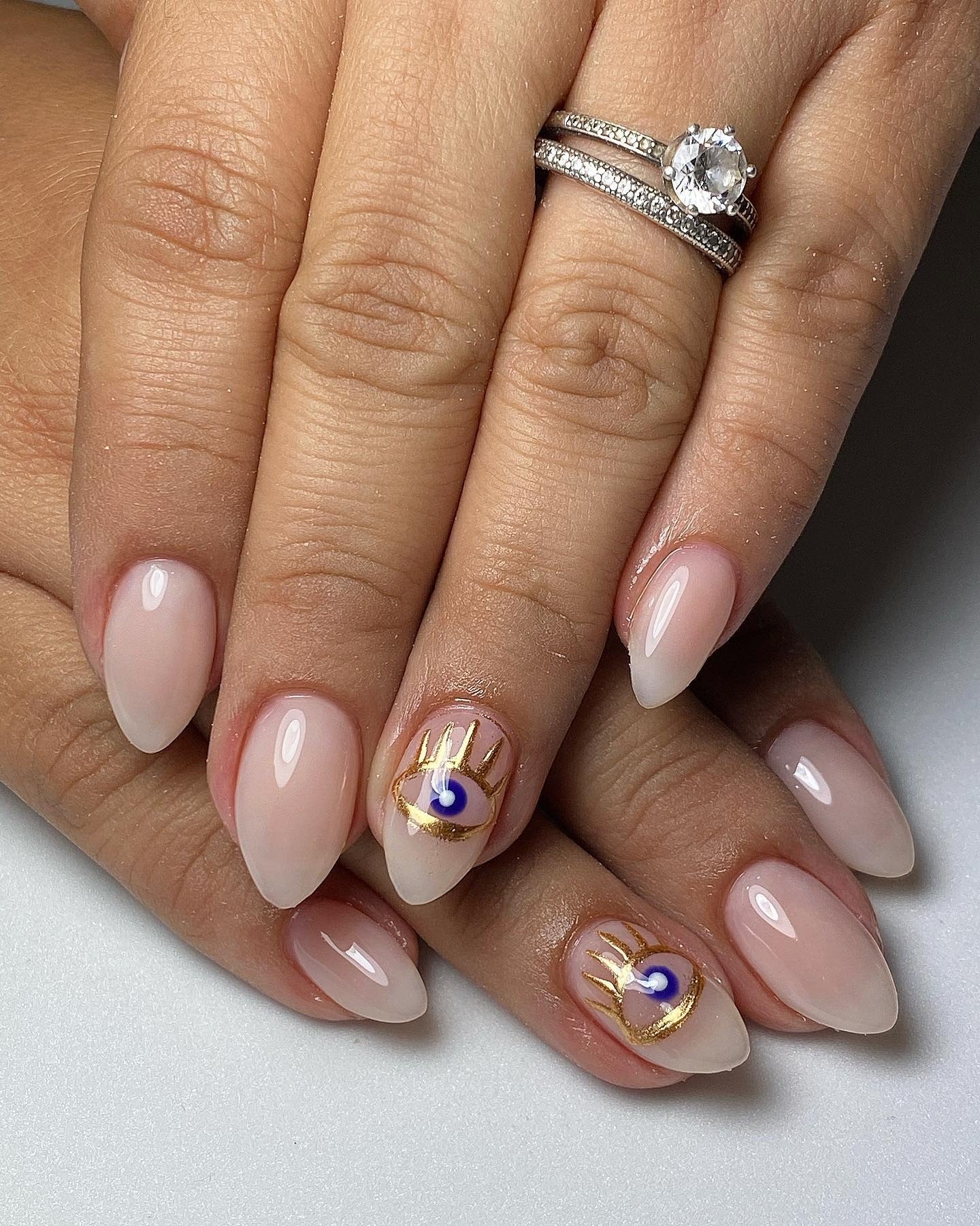 13. Milky Almond Nails with Evil Eye Detail (Milky Nail Ideas)