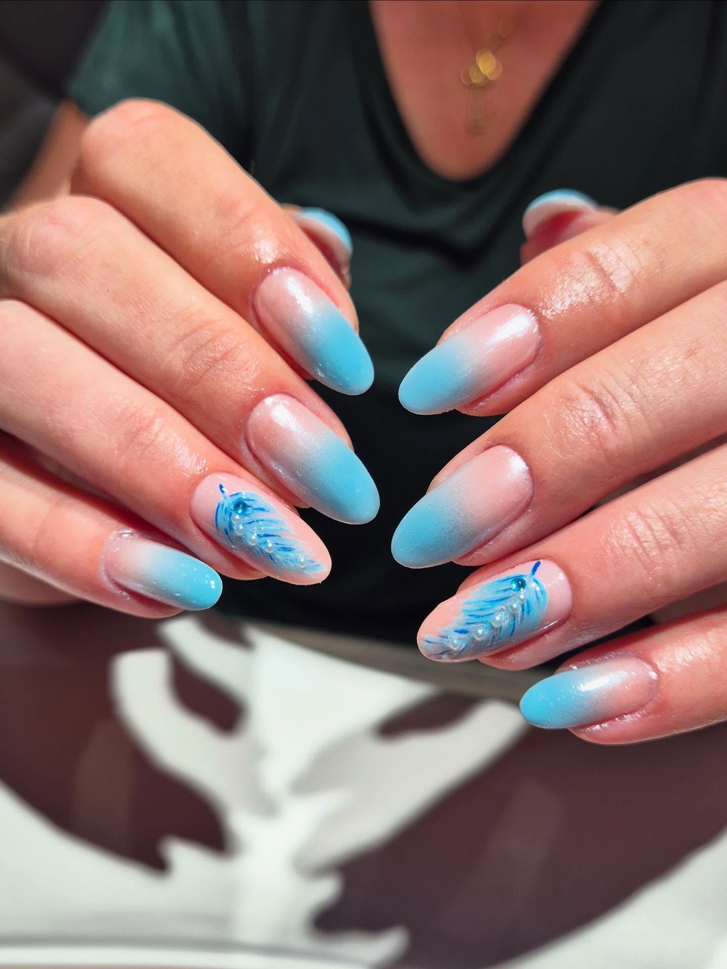 5. Ombre Blue Almond Nails with Feather Detailing (Light Blue Nail Ideas)