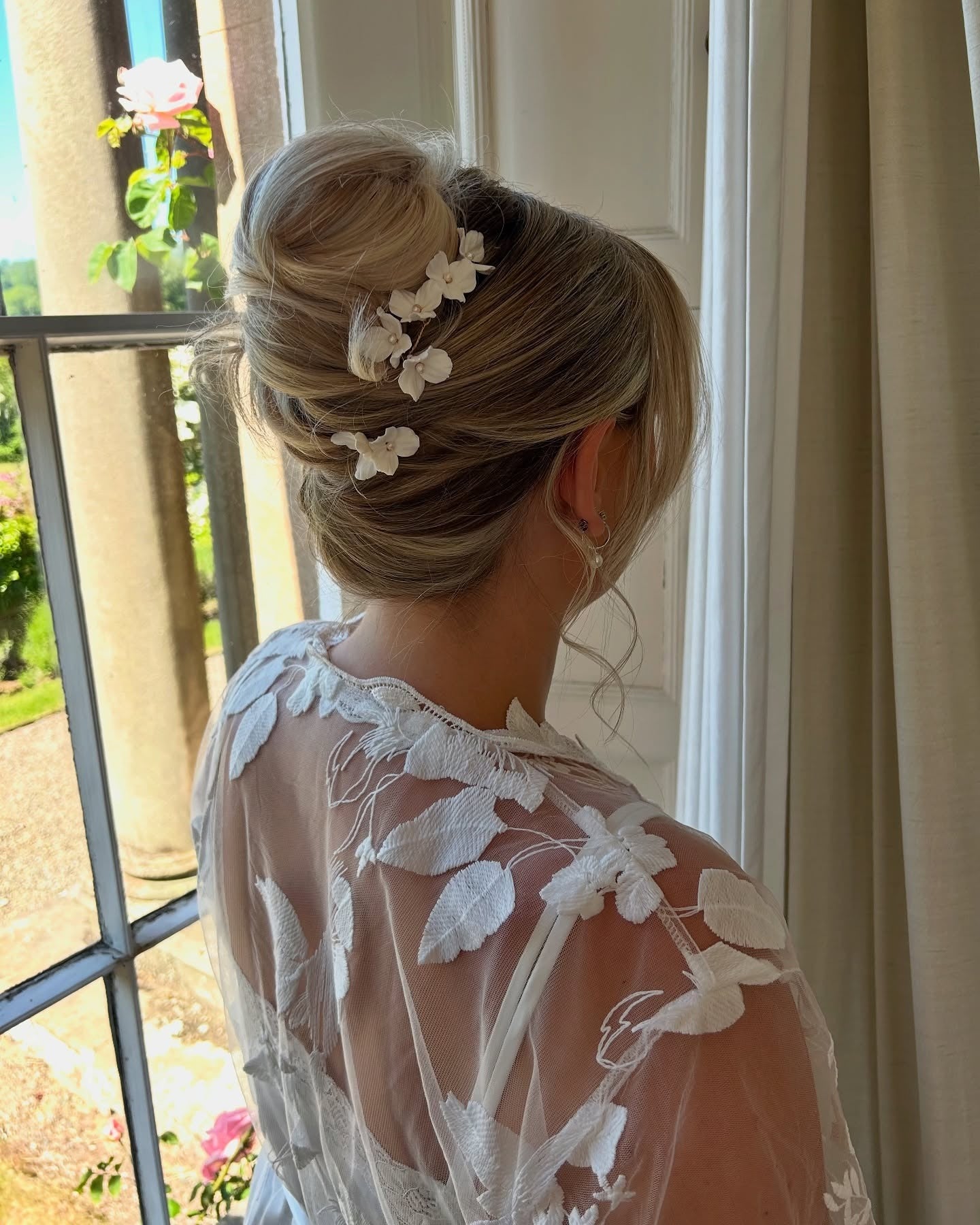 7. Classic Bun with White Floral Accents (Wedding Hairstyles)
