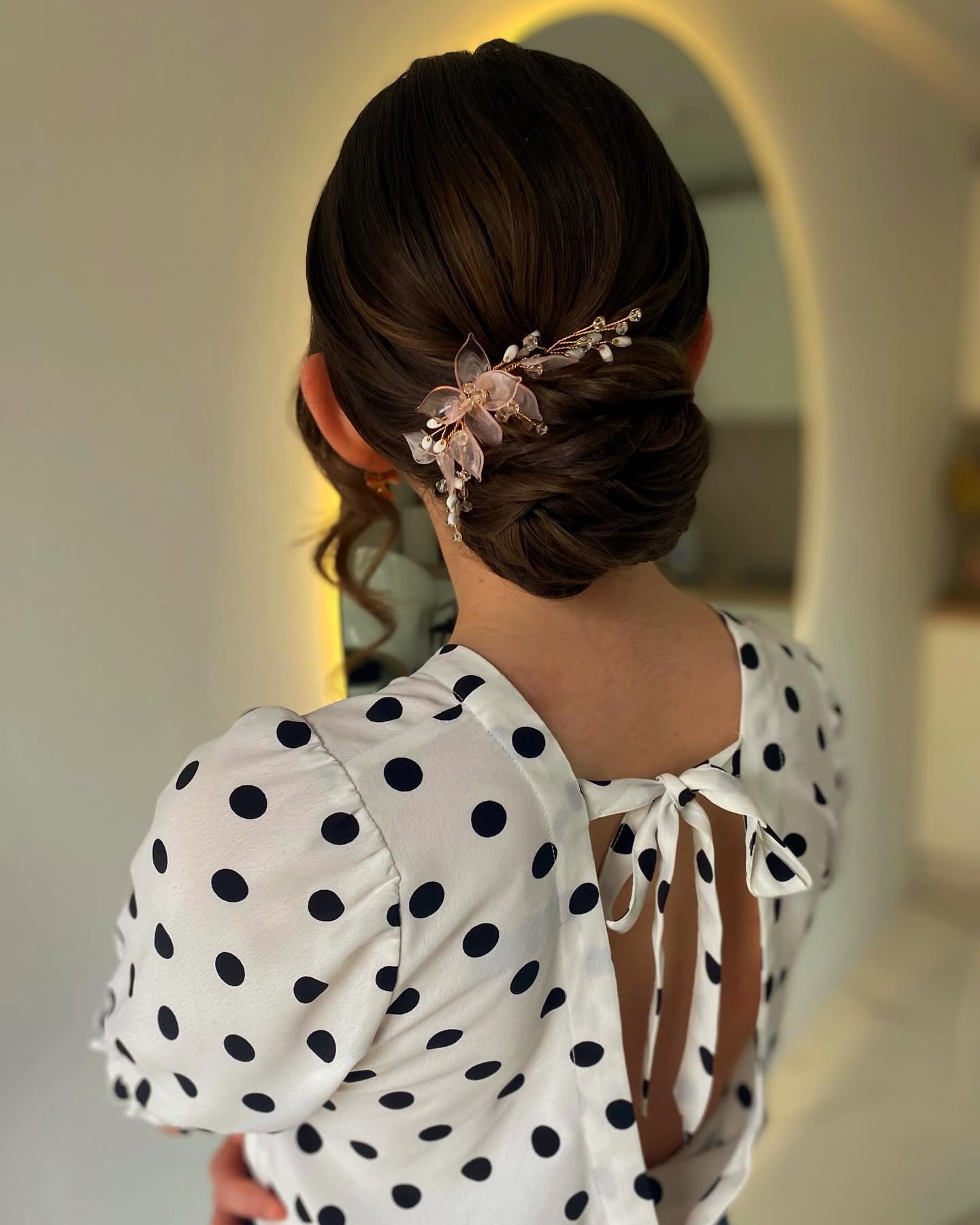 14. Sleek Low Bun with Floral Comb (Wedding Hairstyles)
