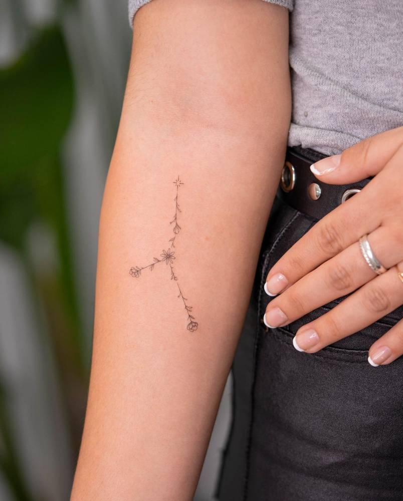 Floral cancer constellation tattoo on the inner forearm