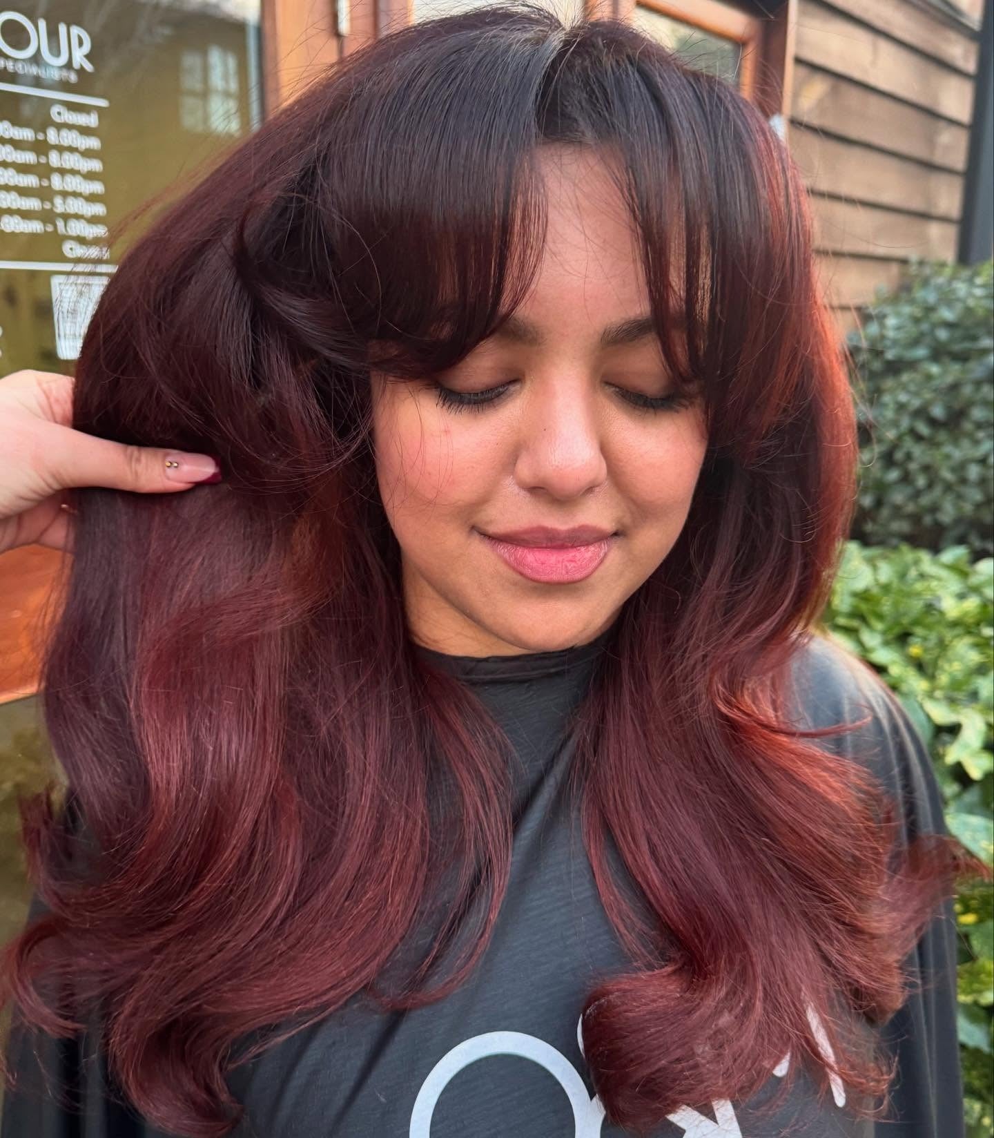 5. Classic Blowout with Rounded Layers and Soft Bangs (Cherry Cola Hair Color)