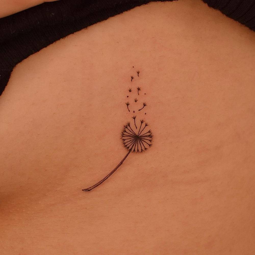 Fine line dandelion seed tattoo on the side boob.