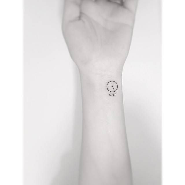 Minimalistic clock tattoo located on the wrist.
