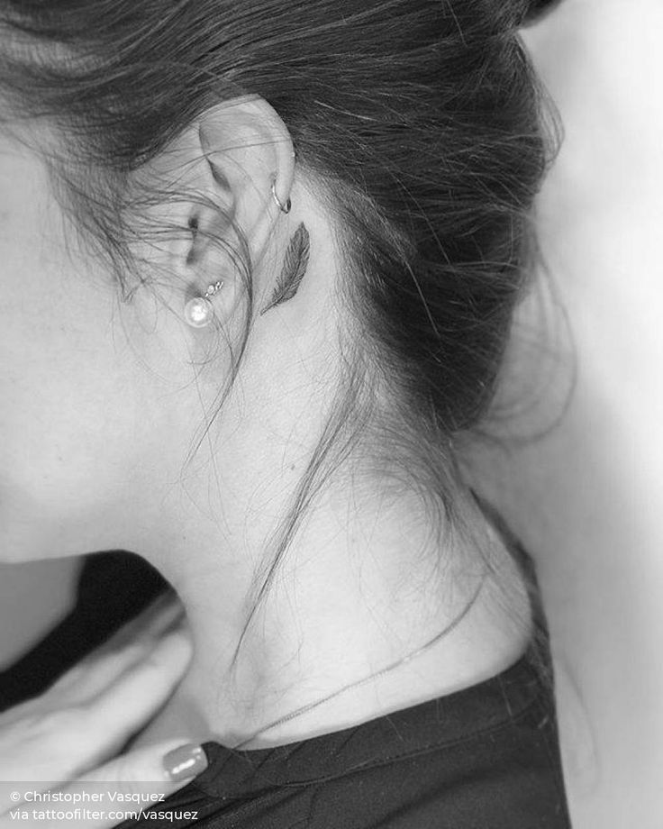Feather tattoo behind the left ear.