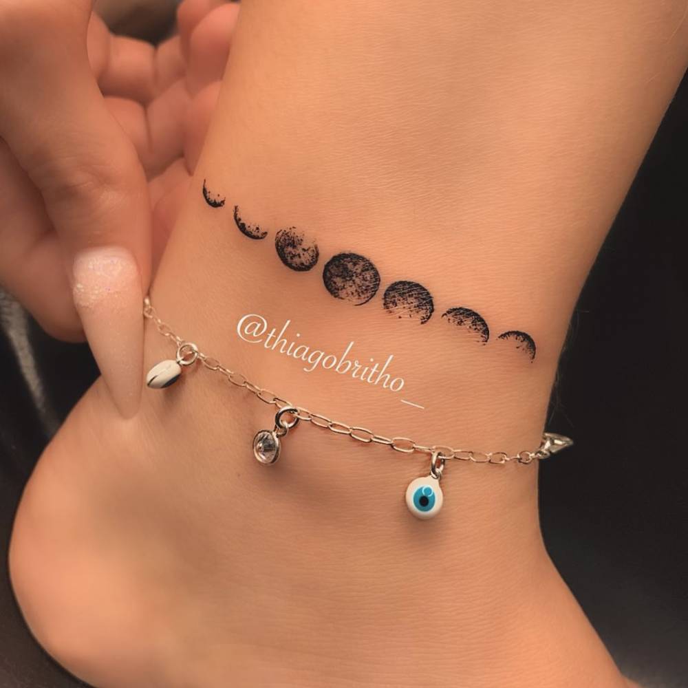 Moon phases tattoo on the ankle.