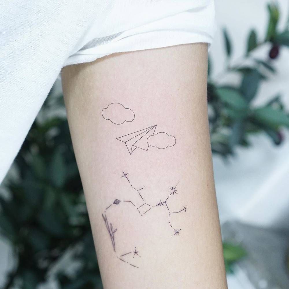 Fine line constellation and paper plane tattoos