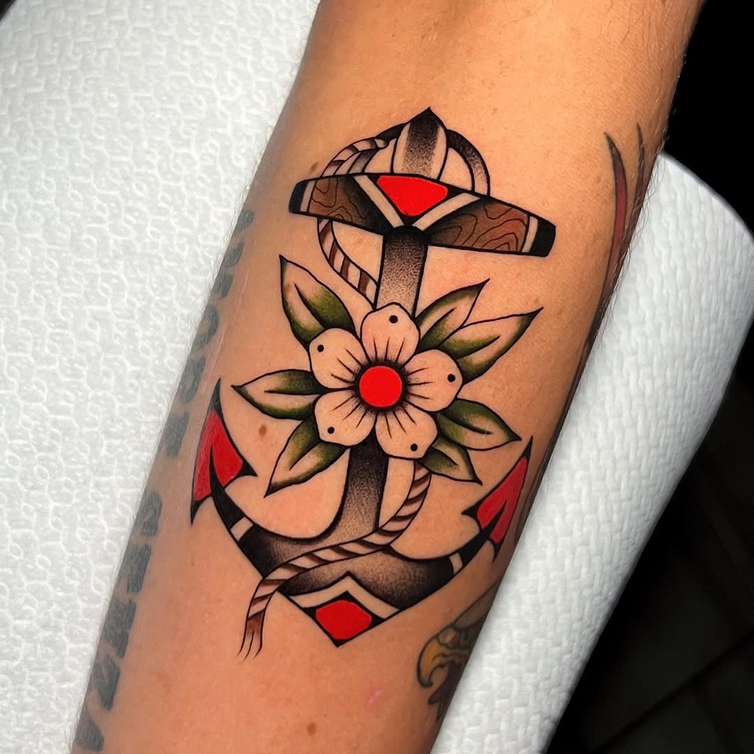 Traditional anchor tattoo with vibrant floral accents