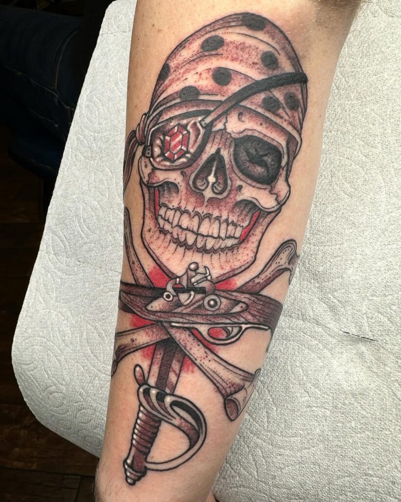 Red Sapphire And Pirate Skull Tat