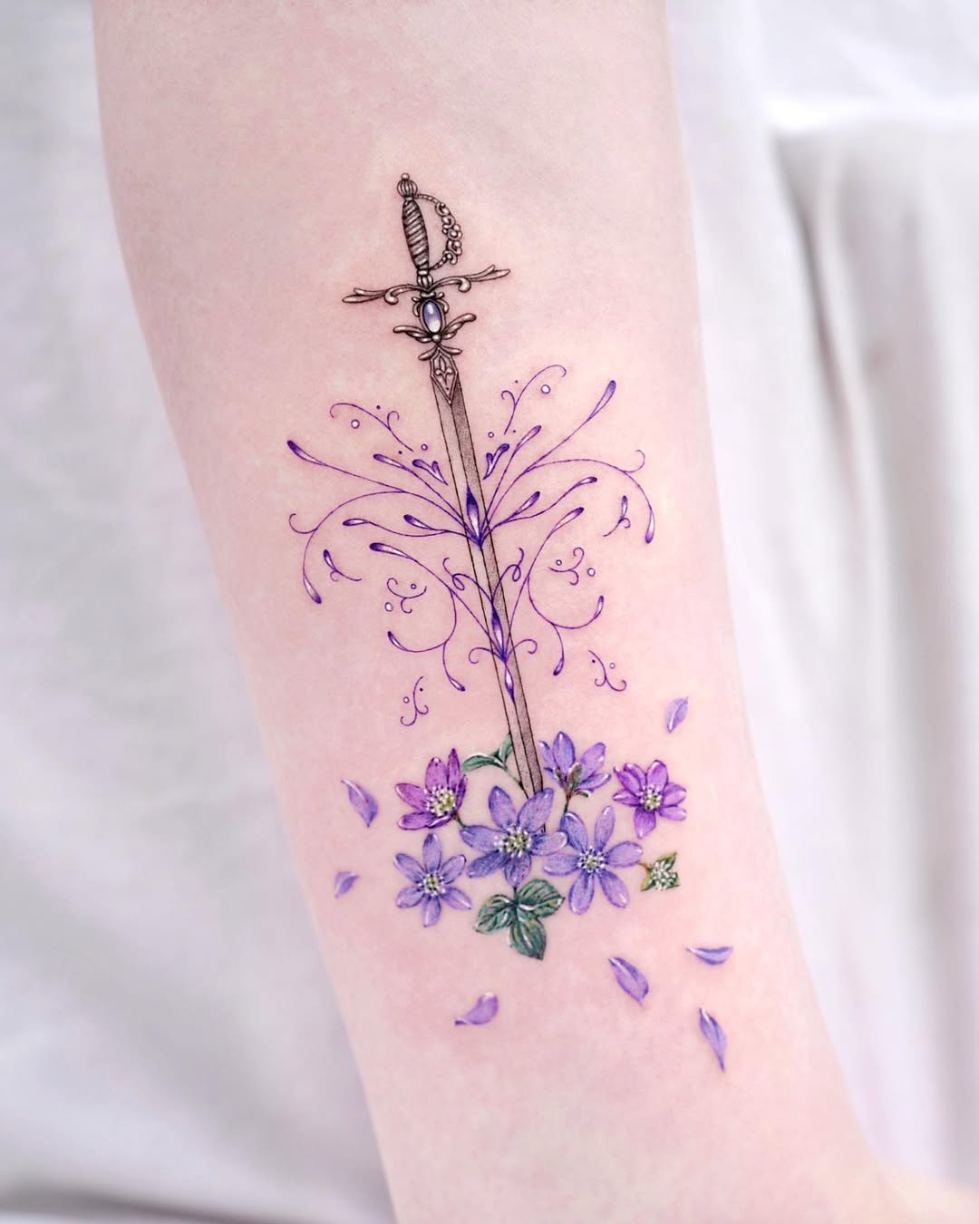 Floral sword tattoo representing inner strength