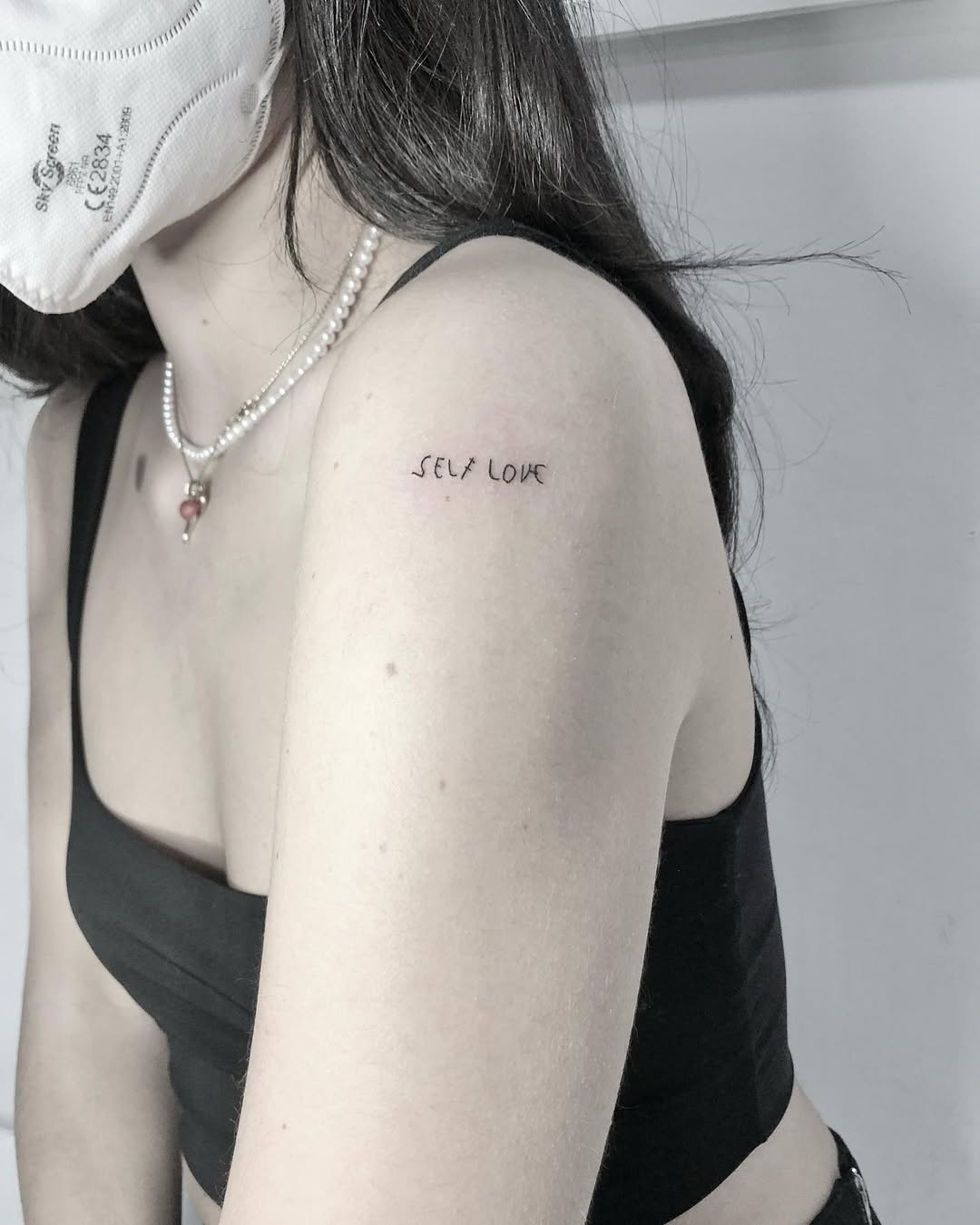 Minimalist self-love tattoo on the shoulder