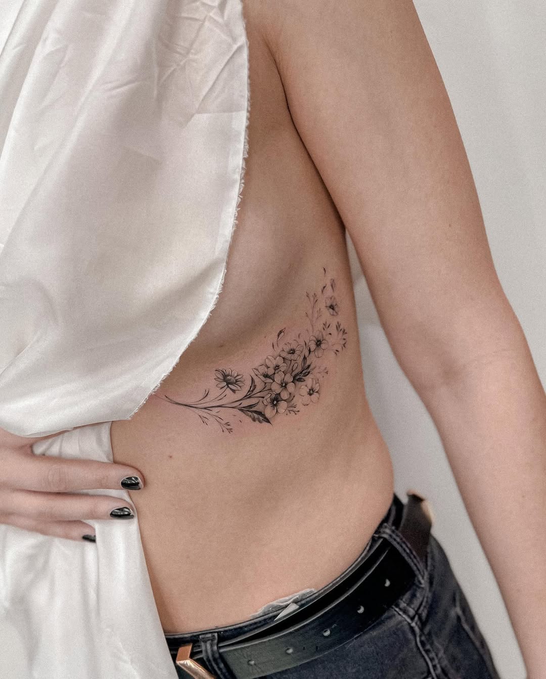 Elegant floral underboob tattoo with delicate details
