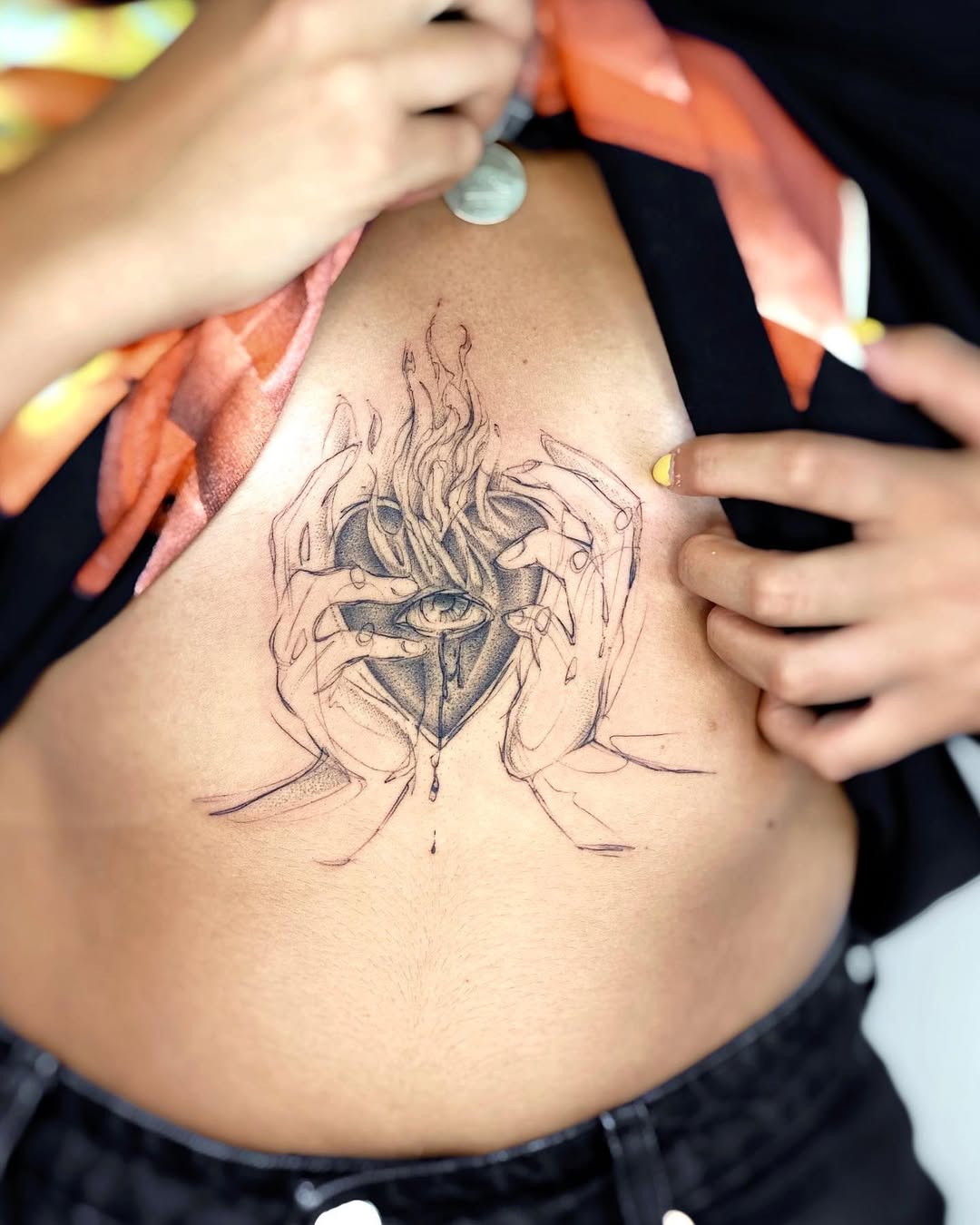 Artistic hands cradling a fiery heart tattoo