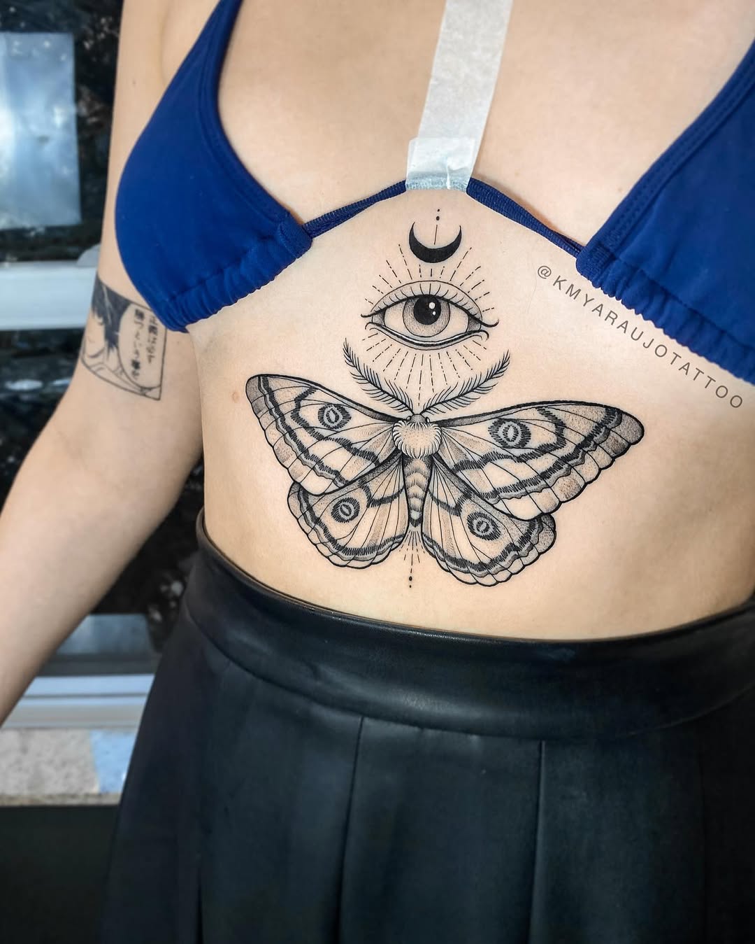 Intricate moth and eye underboob tattoo