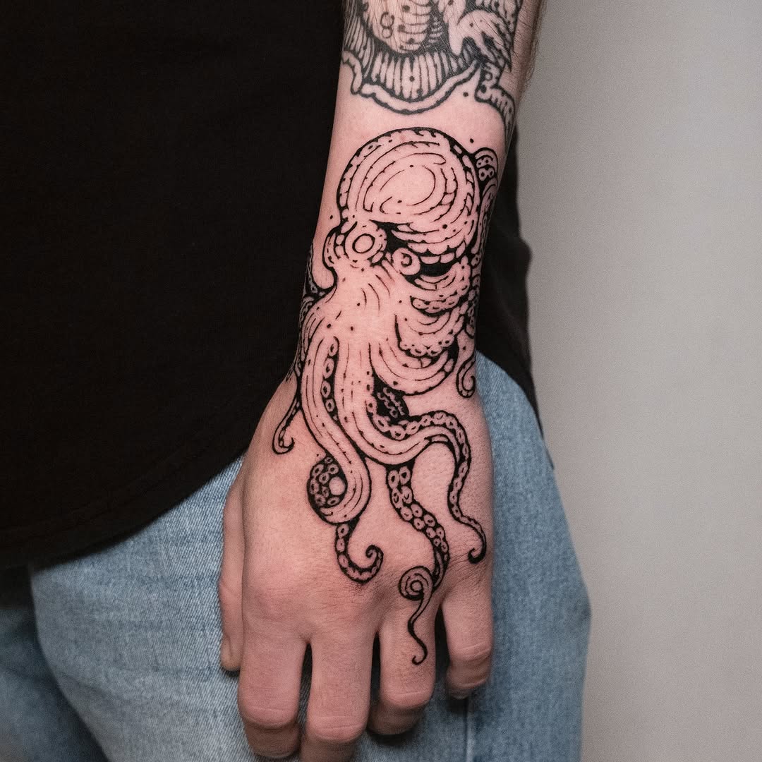 Intricate octopus tattoo wrapping around the arm