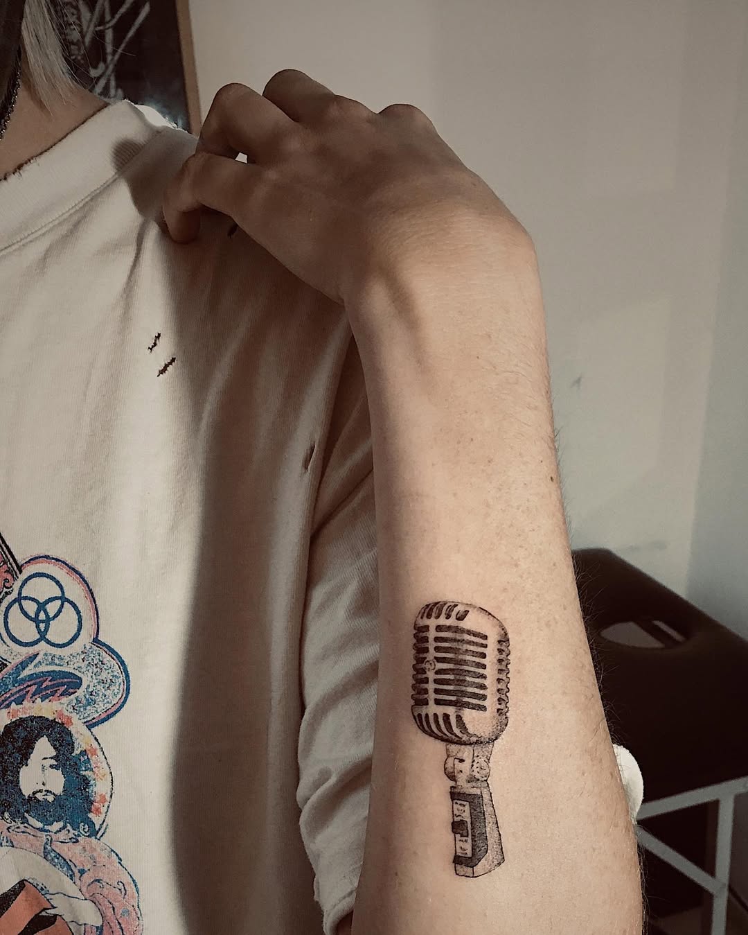 Vintage microphone tattoo captured on inner arm