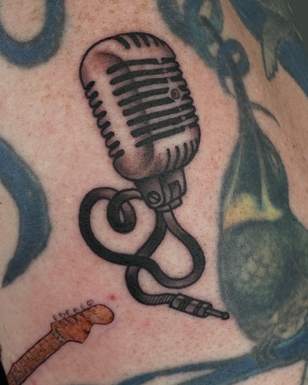 Classic microphone tattoo showcasing artistic detail