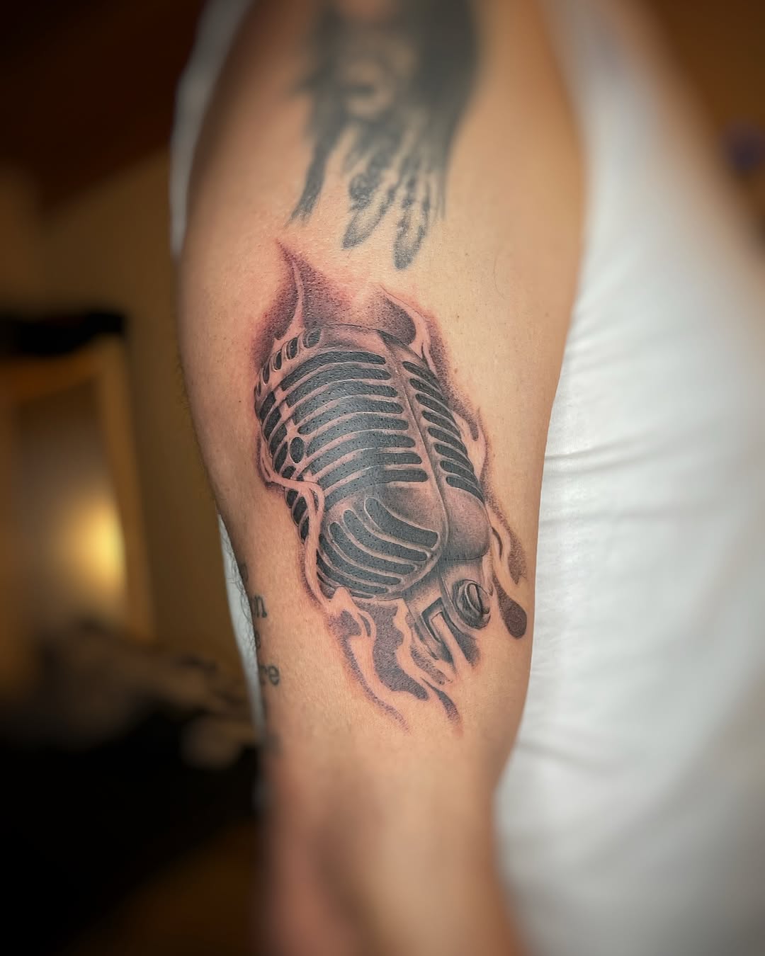 Vintage microphone tattoo with fiery accents