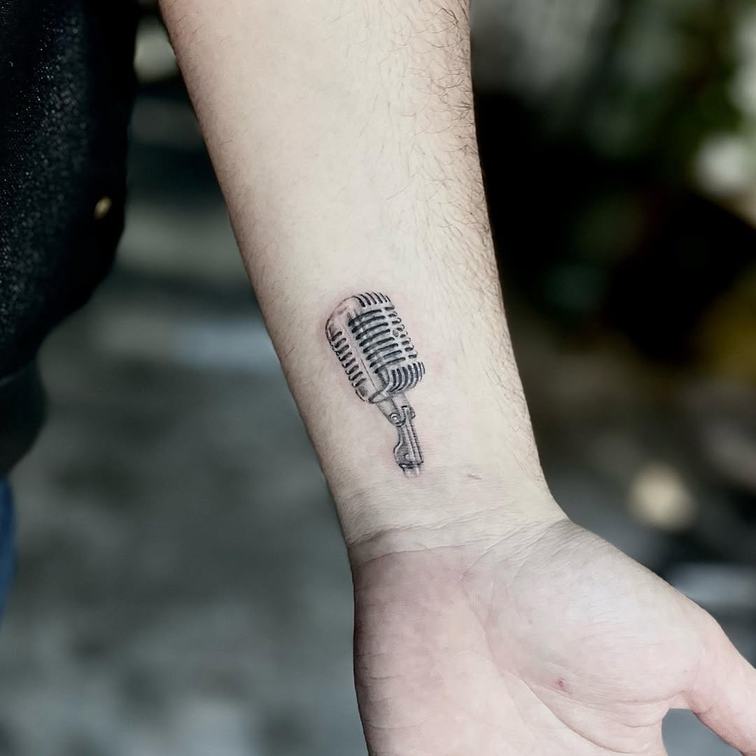 Stylish microphone tattoo on the forearm