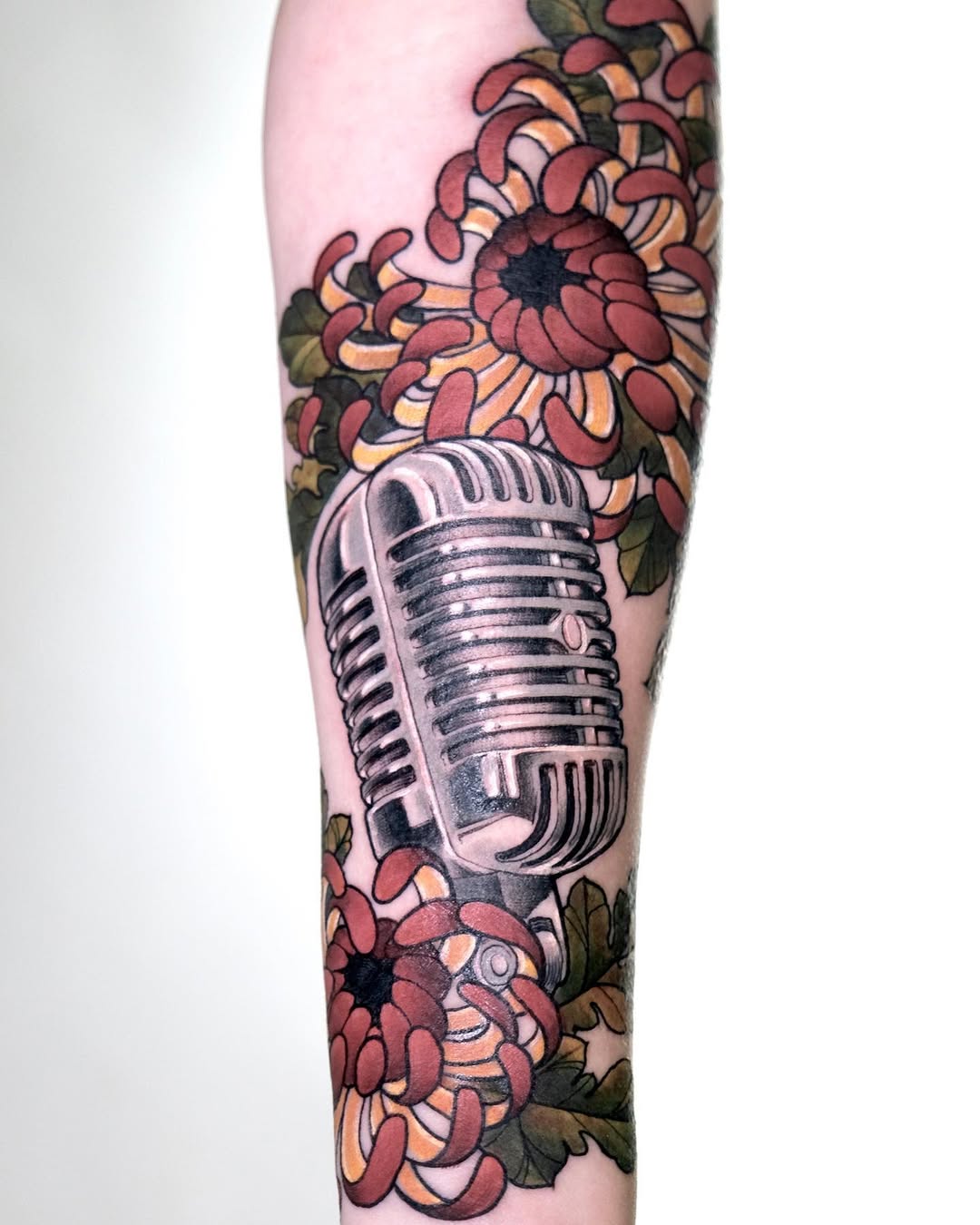 Stylish microphone tattoo surrounded by blooms