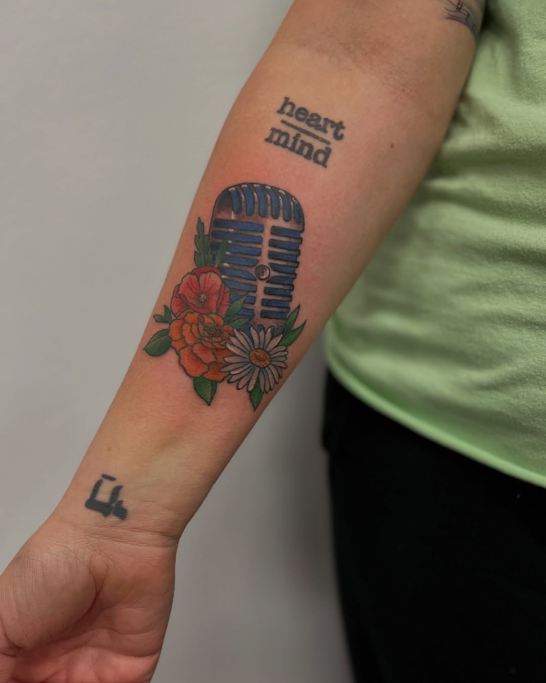 A colorful microphone tattoo with floral accents