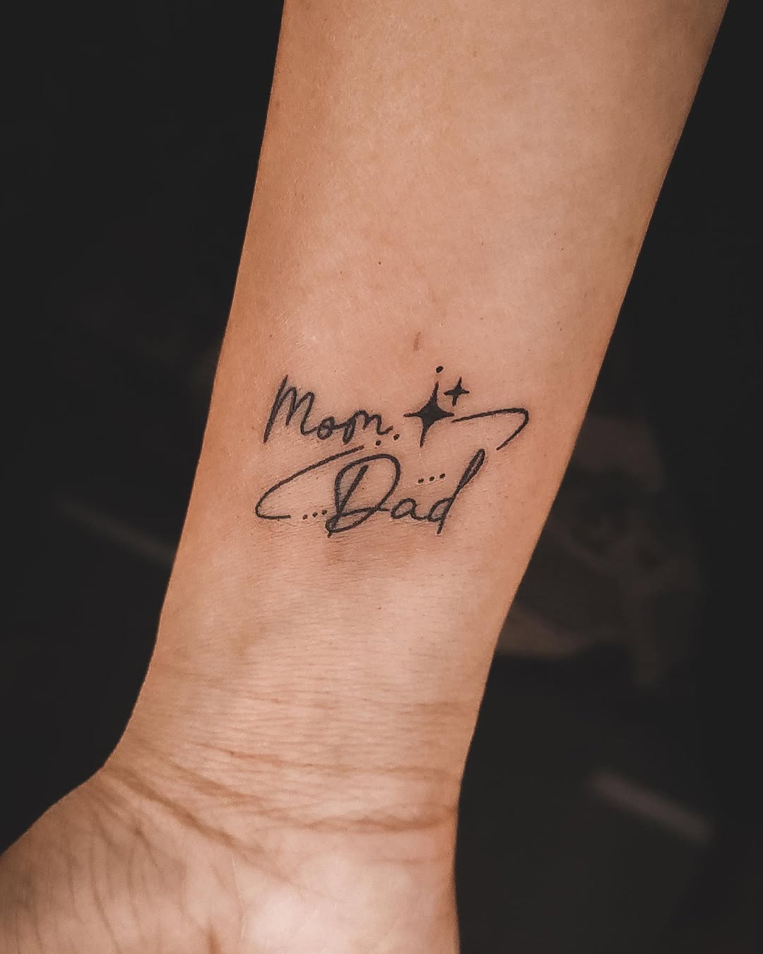 Elegant mom and dad tattoo in cursive