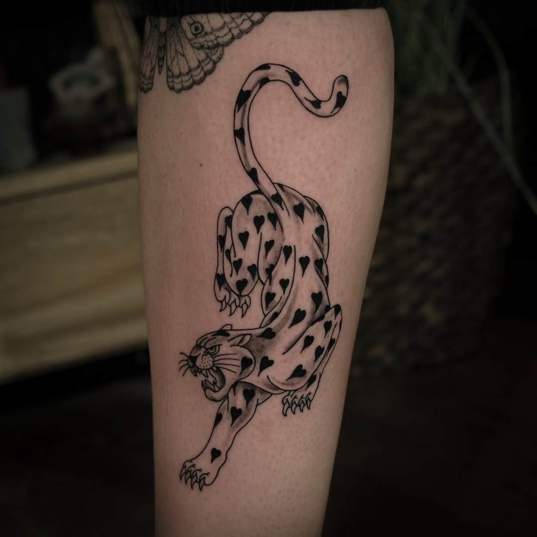 Striking leopard tattoo with heart patterns