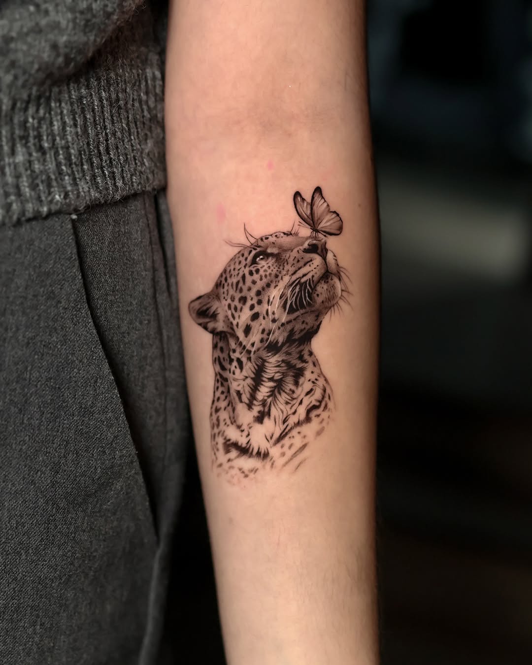 Stunning leopard tattoo with a butterfly accent