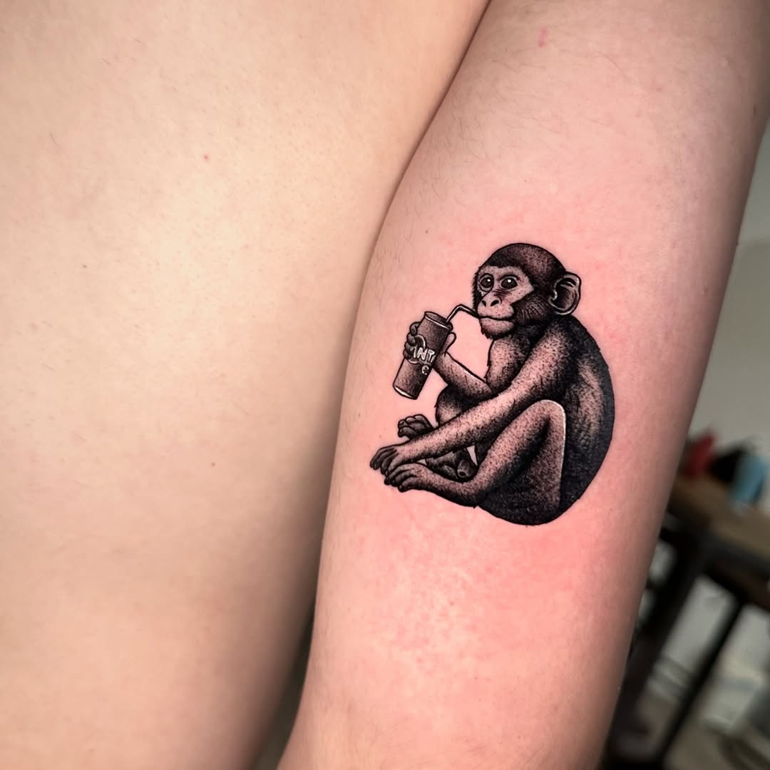 Playful monkey enjoying a drink tattoo
