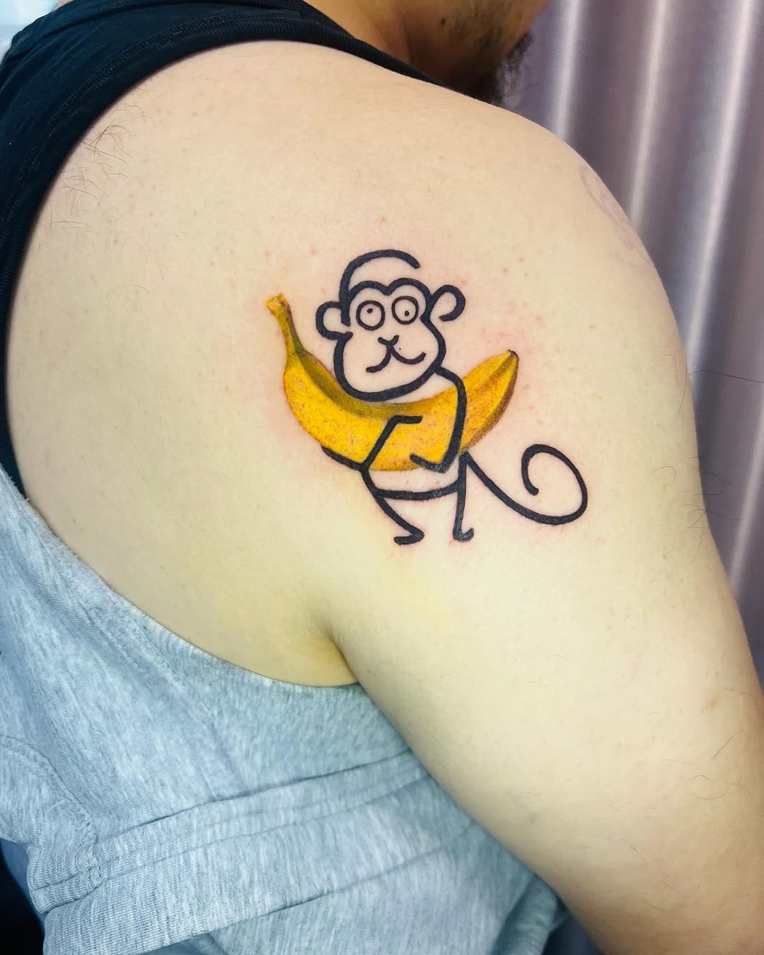 Whimsical monkey tattoo holding a banana