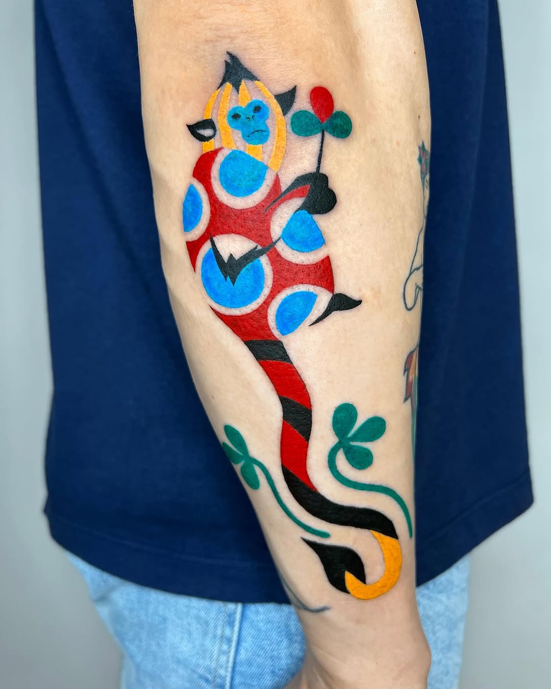 Playful monkey tattoo with vibrant colors and patterns