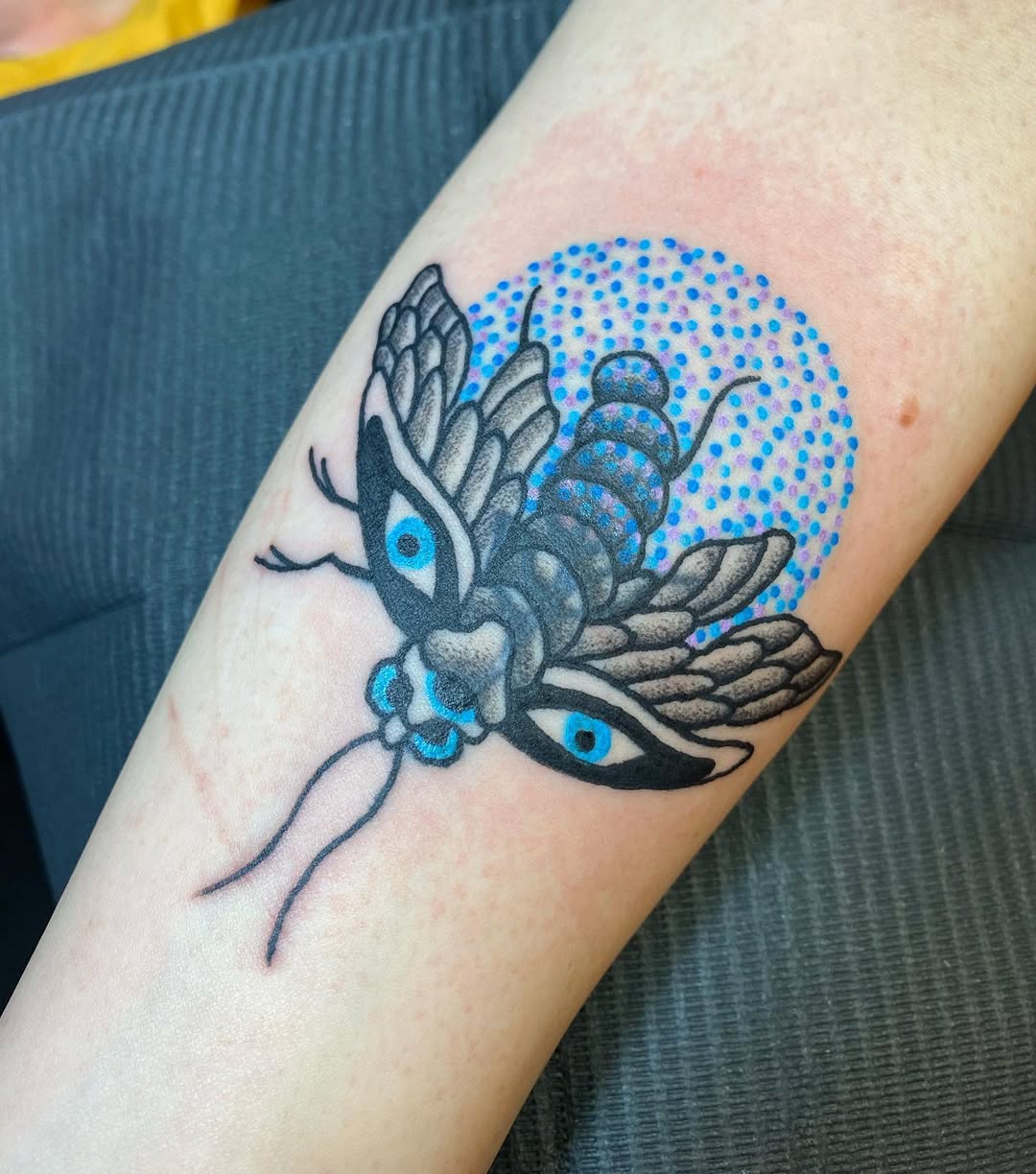 Intricate firefly tattoo with blue dot background