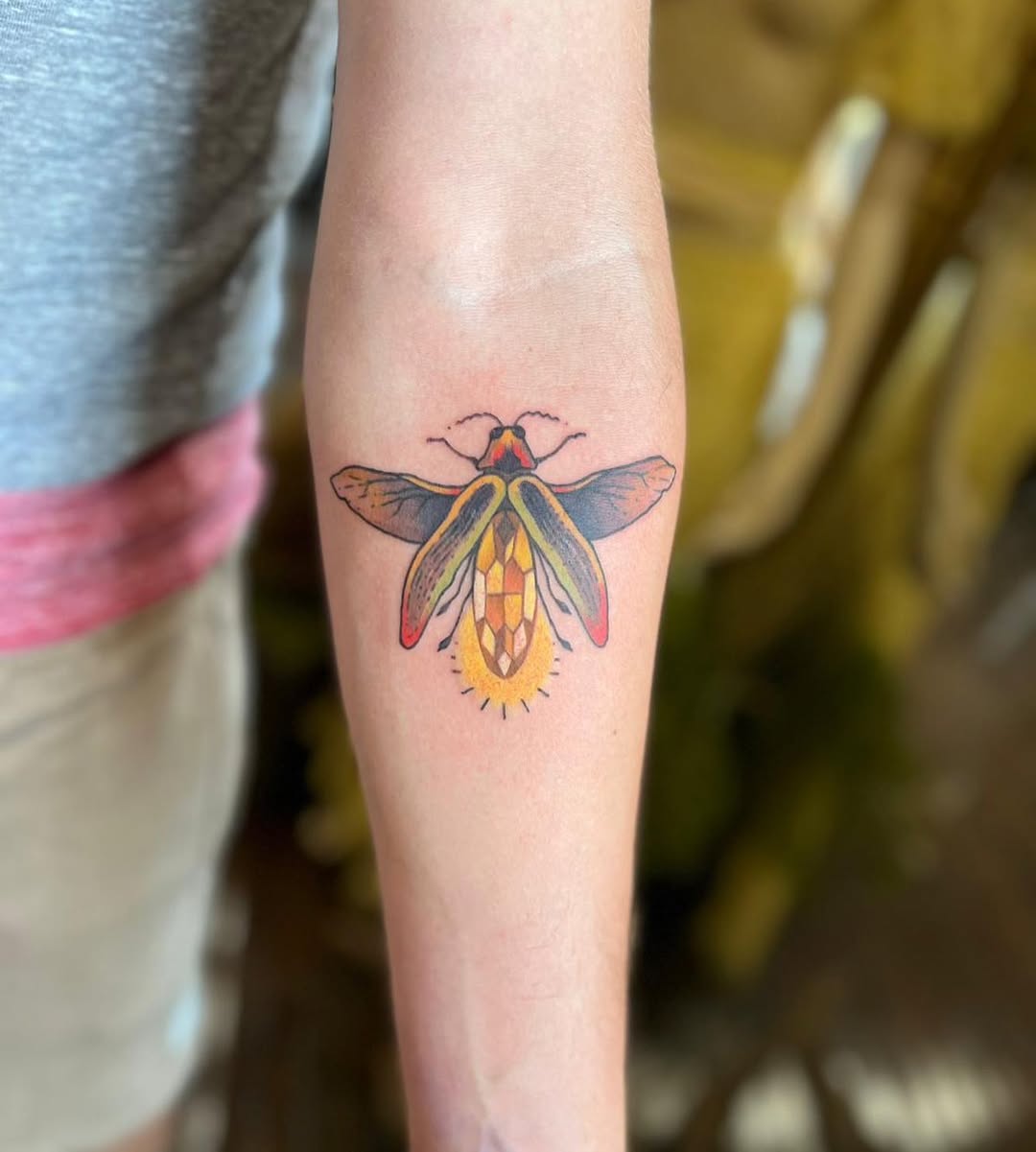 Brightly colored firefly tattoo design on arm